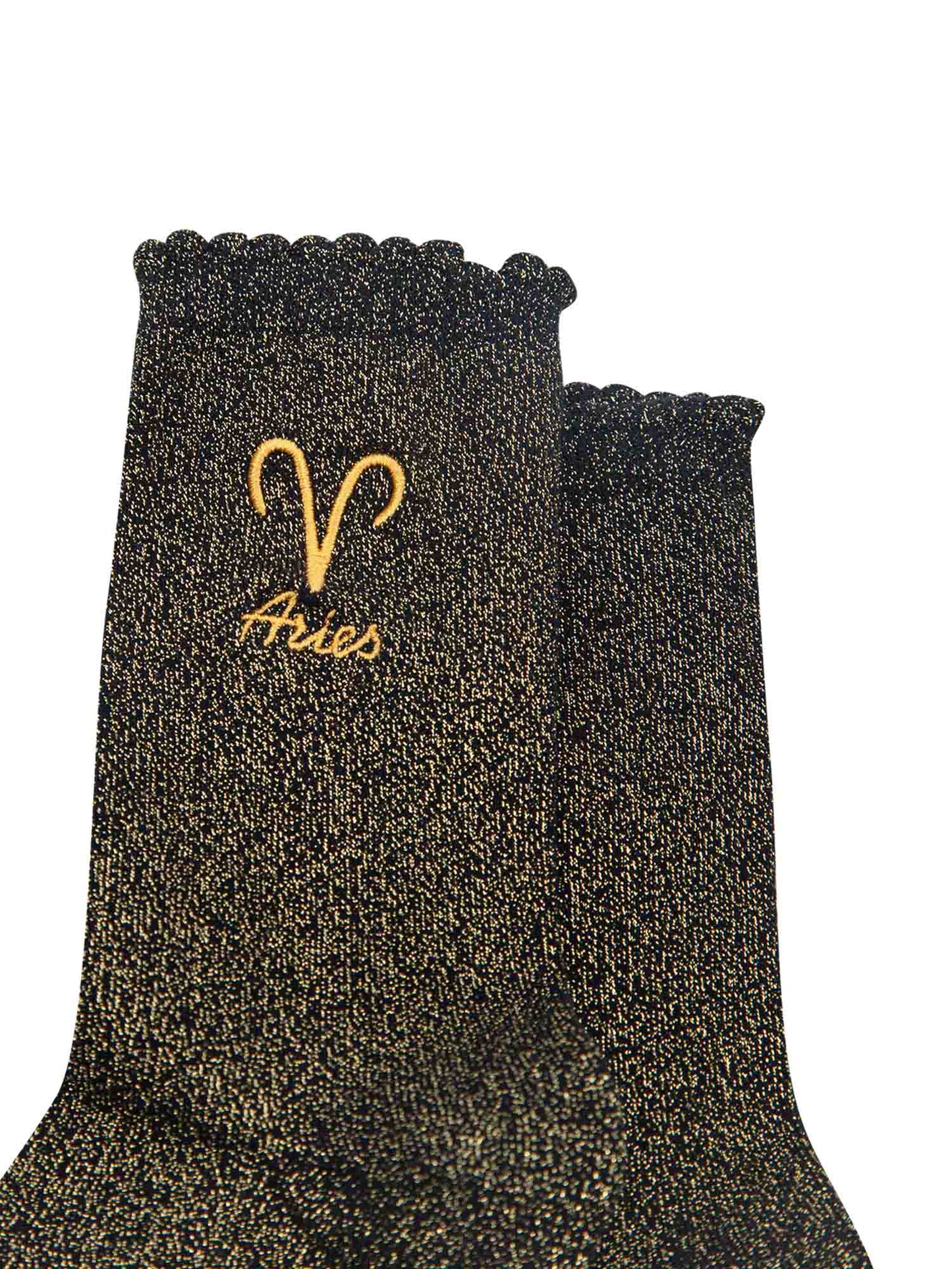 close up of the gold embroidered zodiac detail on the ankle of the socks, showing clearly the symbol of and word aries