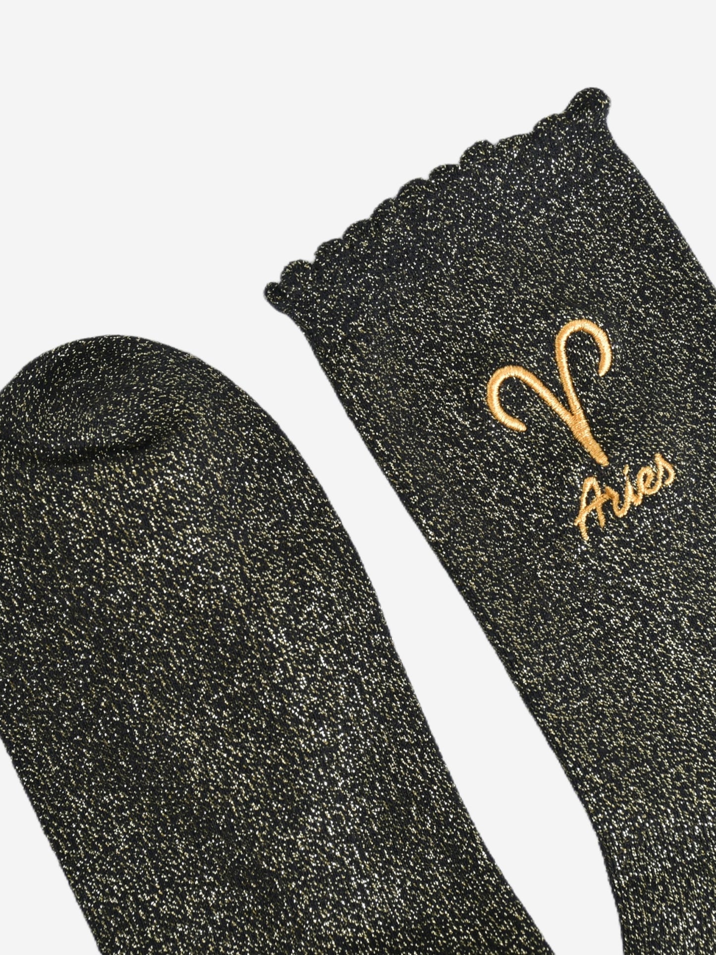 showing the toe and cuff of the socks, they are the same black and gold sparkly colour as the body of the socks, the cuff is scalloped shaped like a slight frill