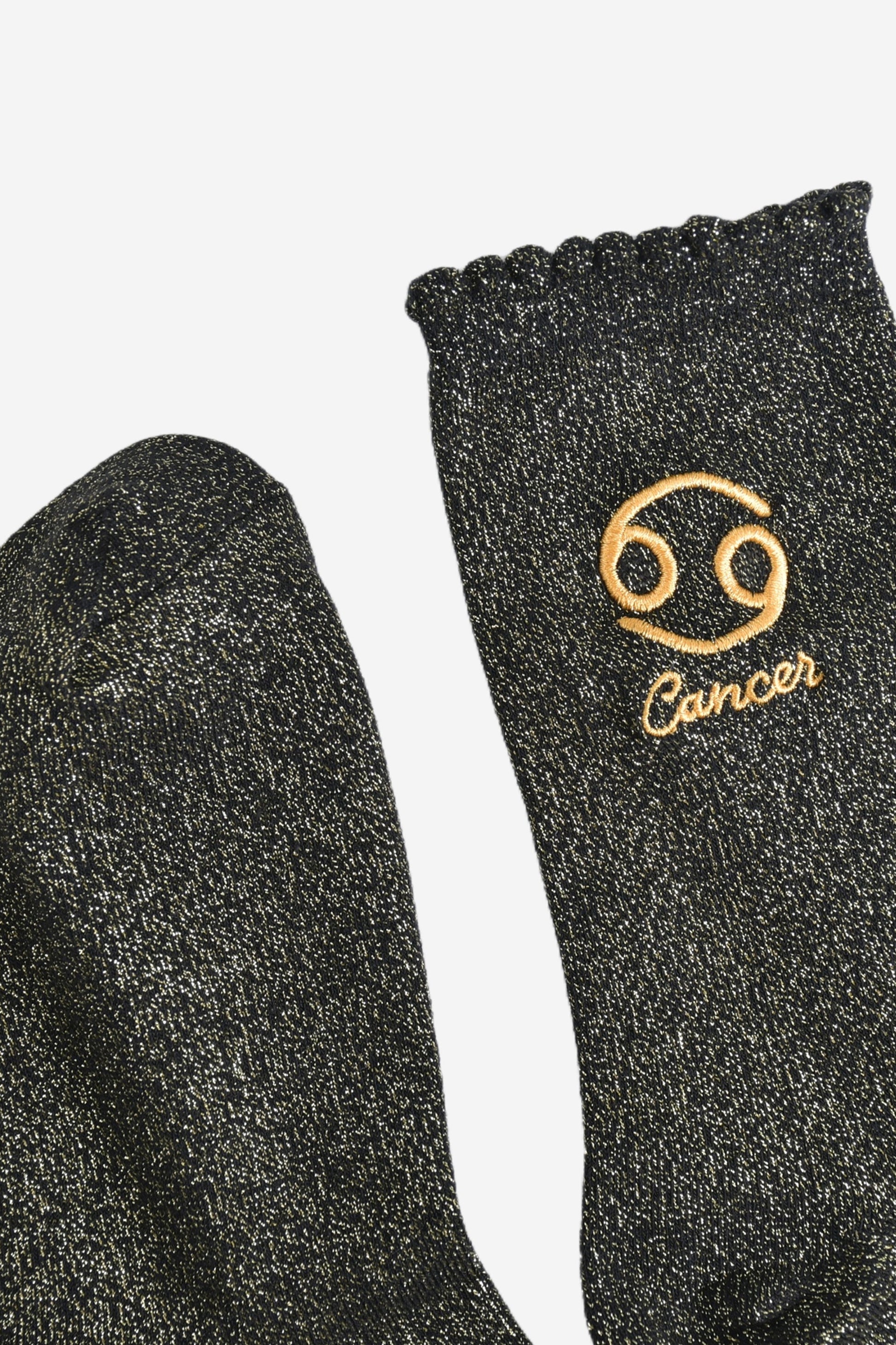 showing the toe and cuff of the socks, they are the same black and gold sparkly colour as the body of the socks, the cuff is scalloped shaped like a slight frill