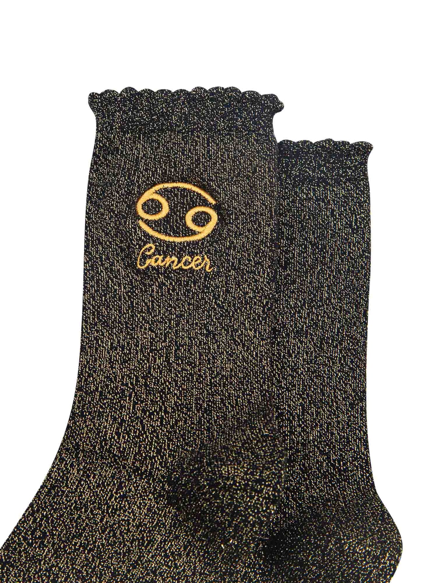 close up of the gold embroidered zodiac detail on the ankle of the socks, showing clearly the symbol of and word cancer