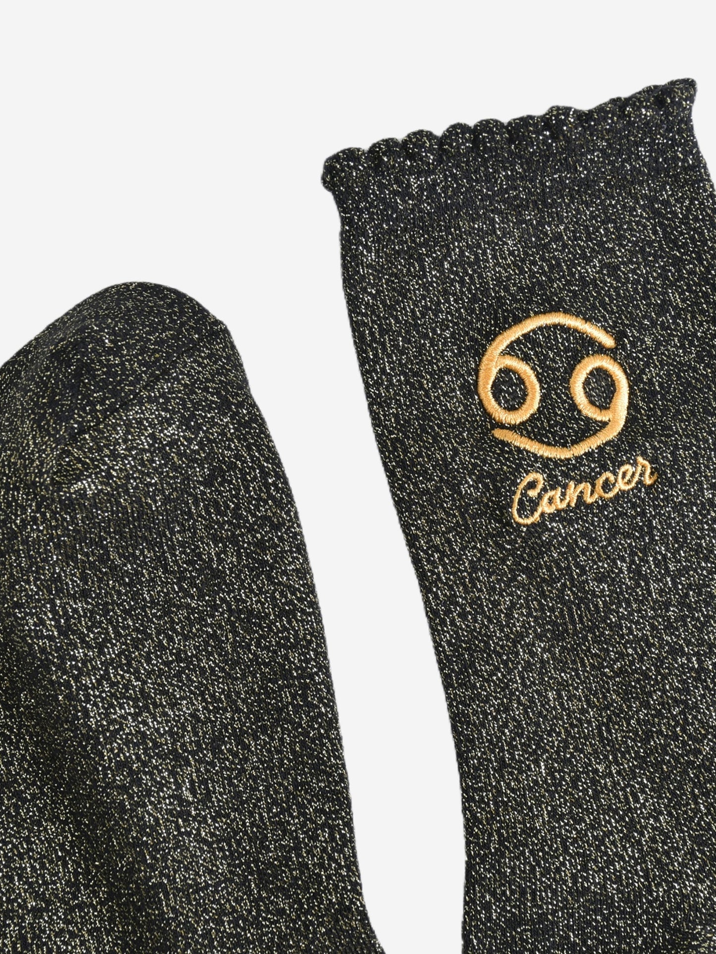 showing the toe and cuff of the socks, they are the same black and gold sparkly colour as the body of the socks, the cuff is scalloped shaped like a slight frill