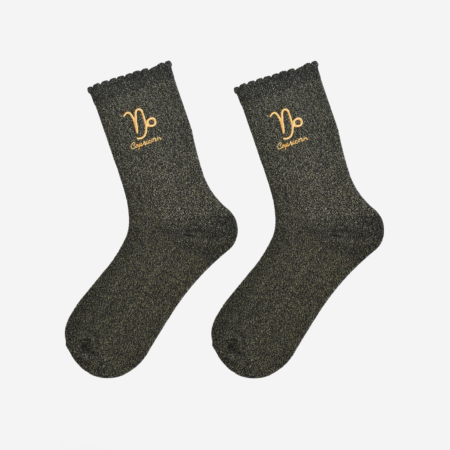 black and gold glitter embroidered capricorn socks laying flat, showing the all over gold glitter sparkle