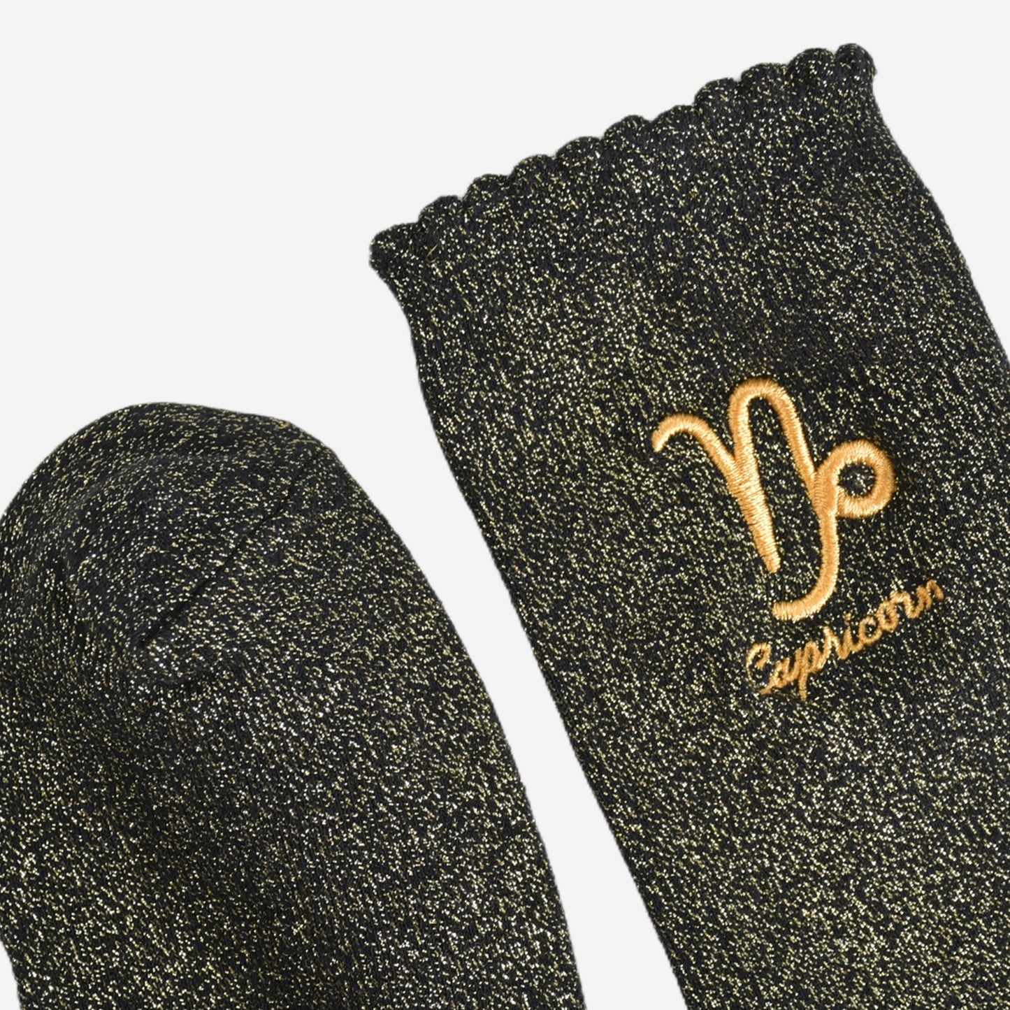 showing the toe and cuff of the socks, they are the same black and gold sparkly colour as the body of the socks, the cuff is scalloped shaped like a slight frill