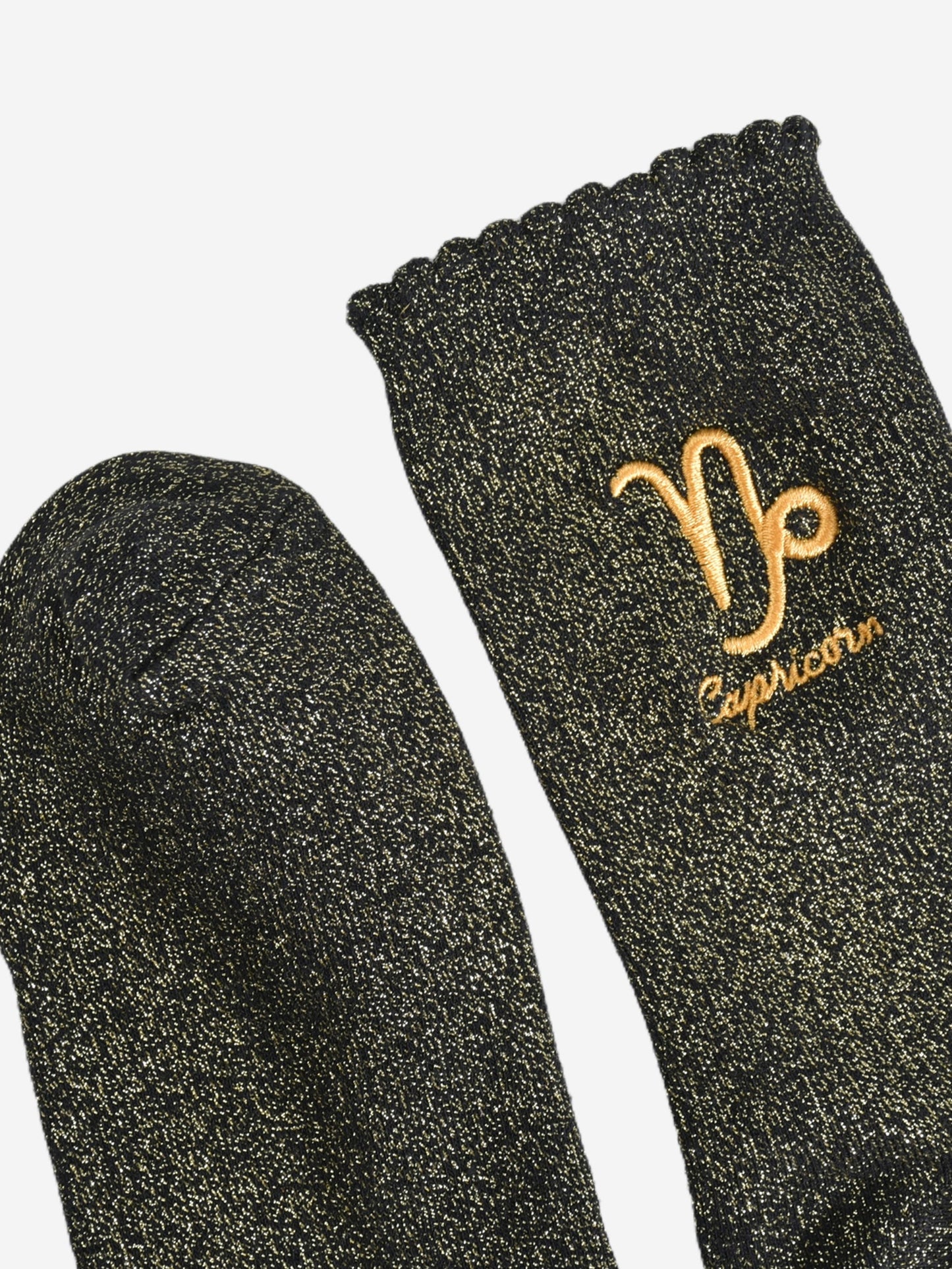 showing the toe and cuff of the socks, they are the same black and gold sparkly colour as the body of the socks, the cuff is scalloped shaped like a slight frill