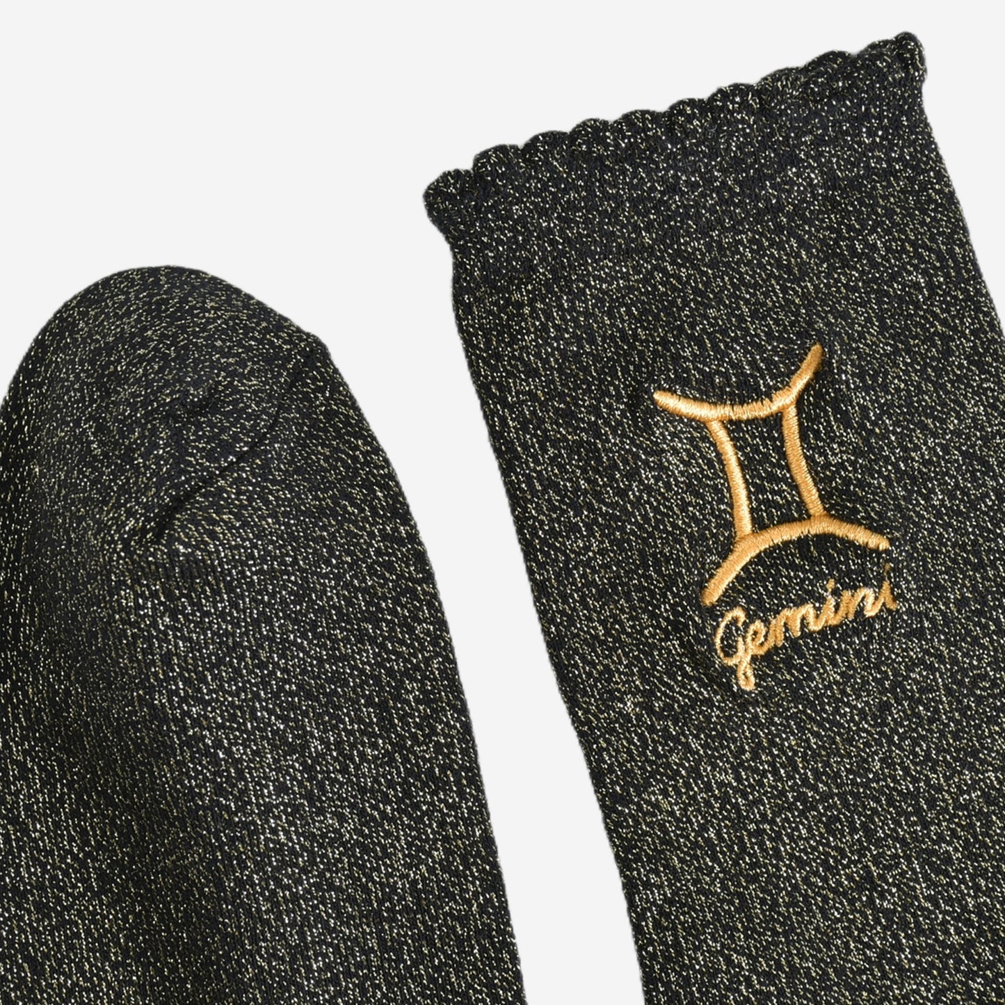 showing the toe and cuff of the socks, they are the same black and gold sparkly colour as the body of the socks, the cuff is scalloped shaped like a slight frill