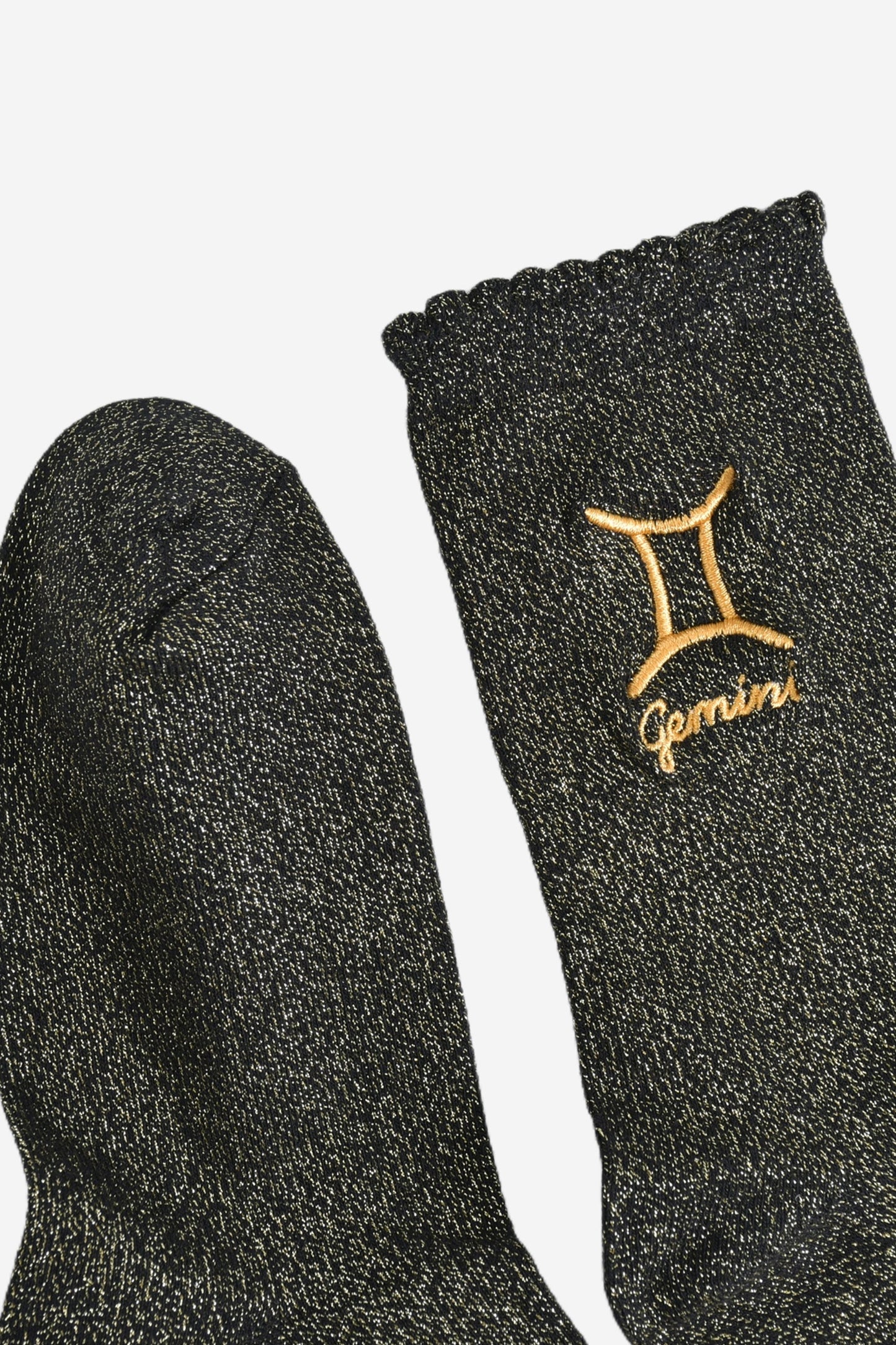 showing the toe and cuff of the socks, they are the same black and gold sparkly colour as the body of the socks, the cuff is scalloped shaped like a slight frill