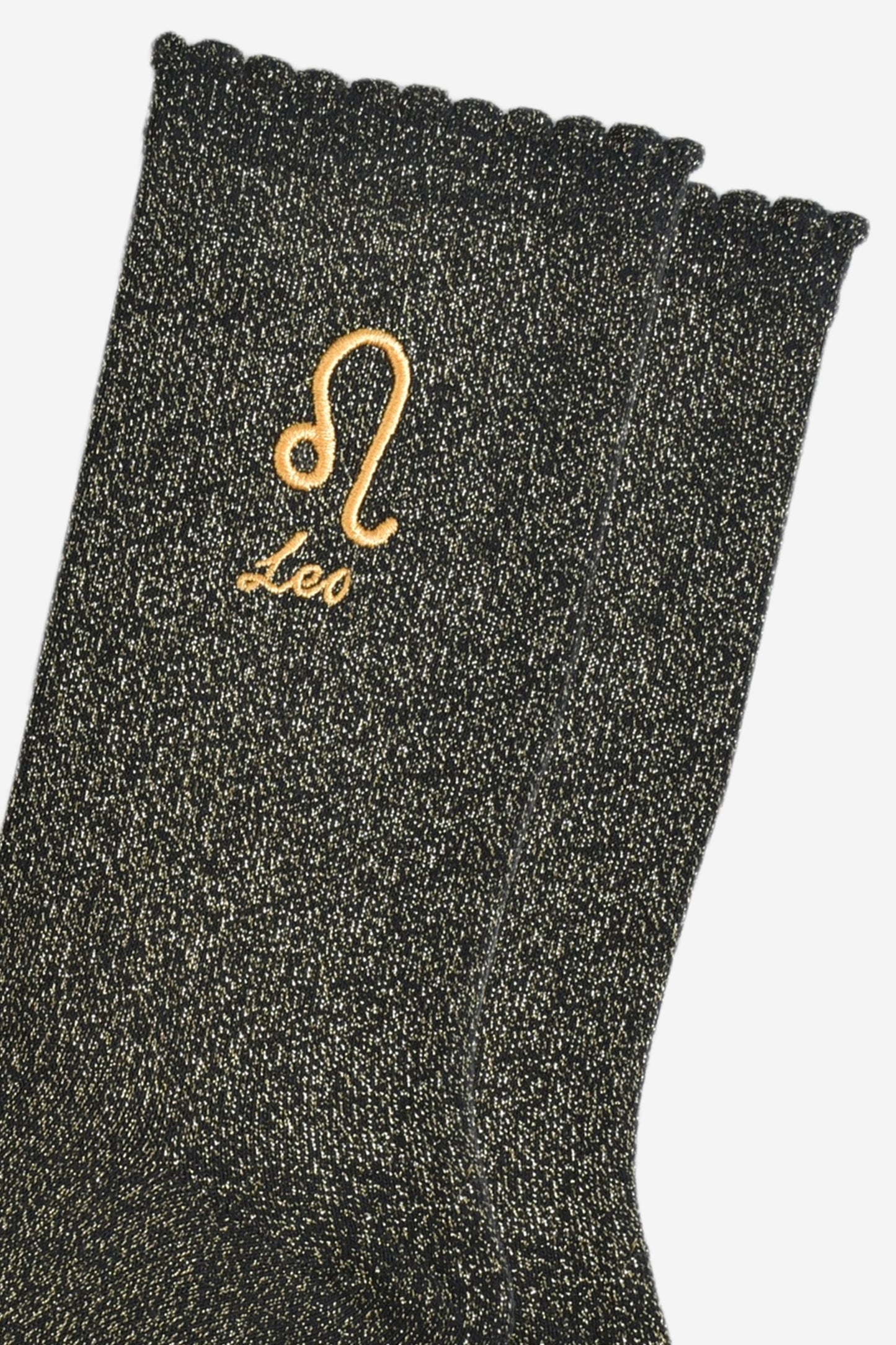 close up of the gold embroidered zodiac detail on the ankle of the socks, showing clearly the symbol of and word leo