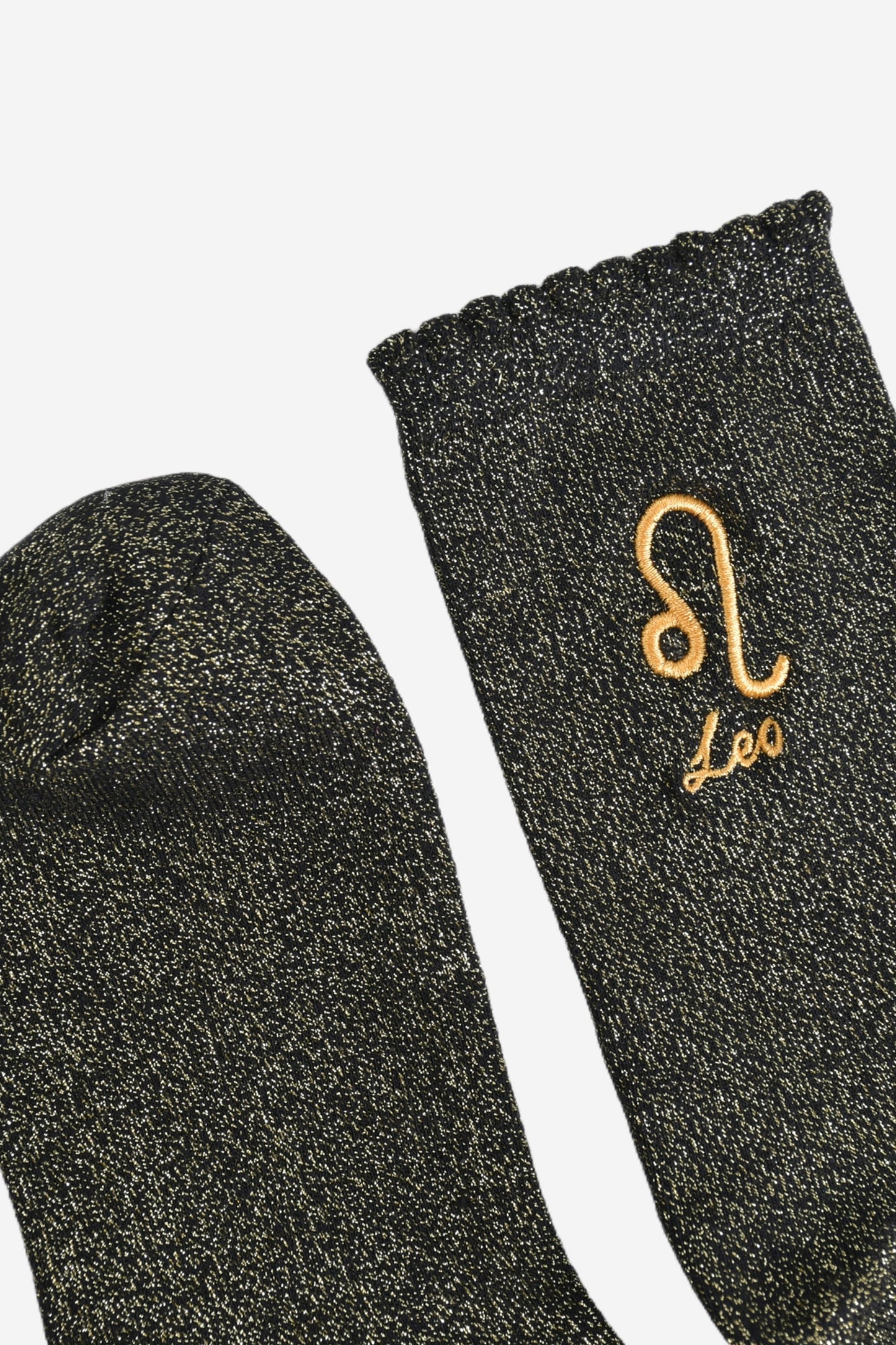 showing the toe and cuff of the socks, they are the same black and gold sparkly colour as the body of the socks, the cuff is scalloped shaped like a slight frill