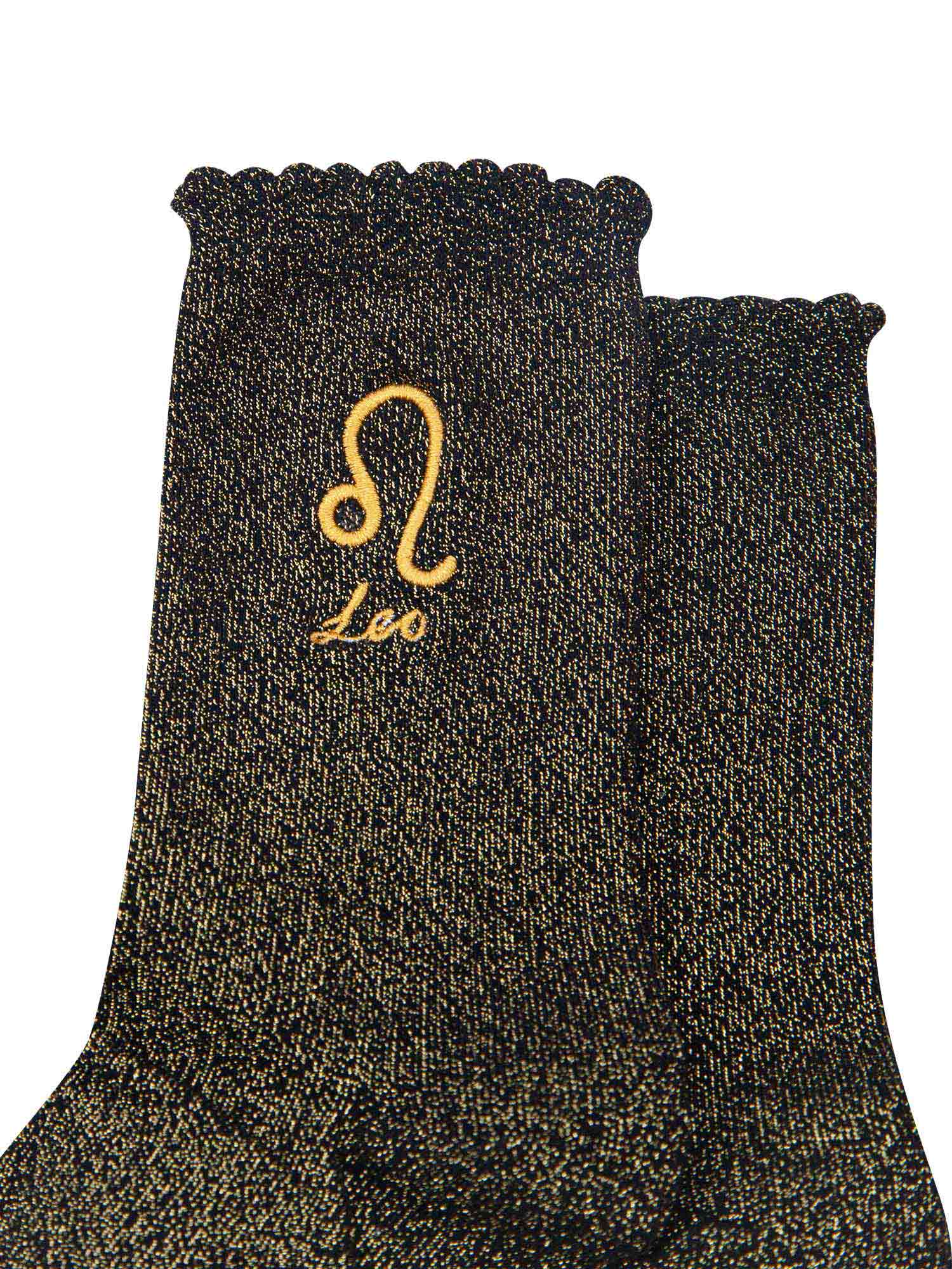 close up of the gold embroidered zodiac detail on the ankle of the socks, showing clearly the symbol of and word leo
