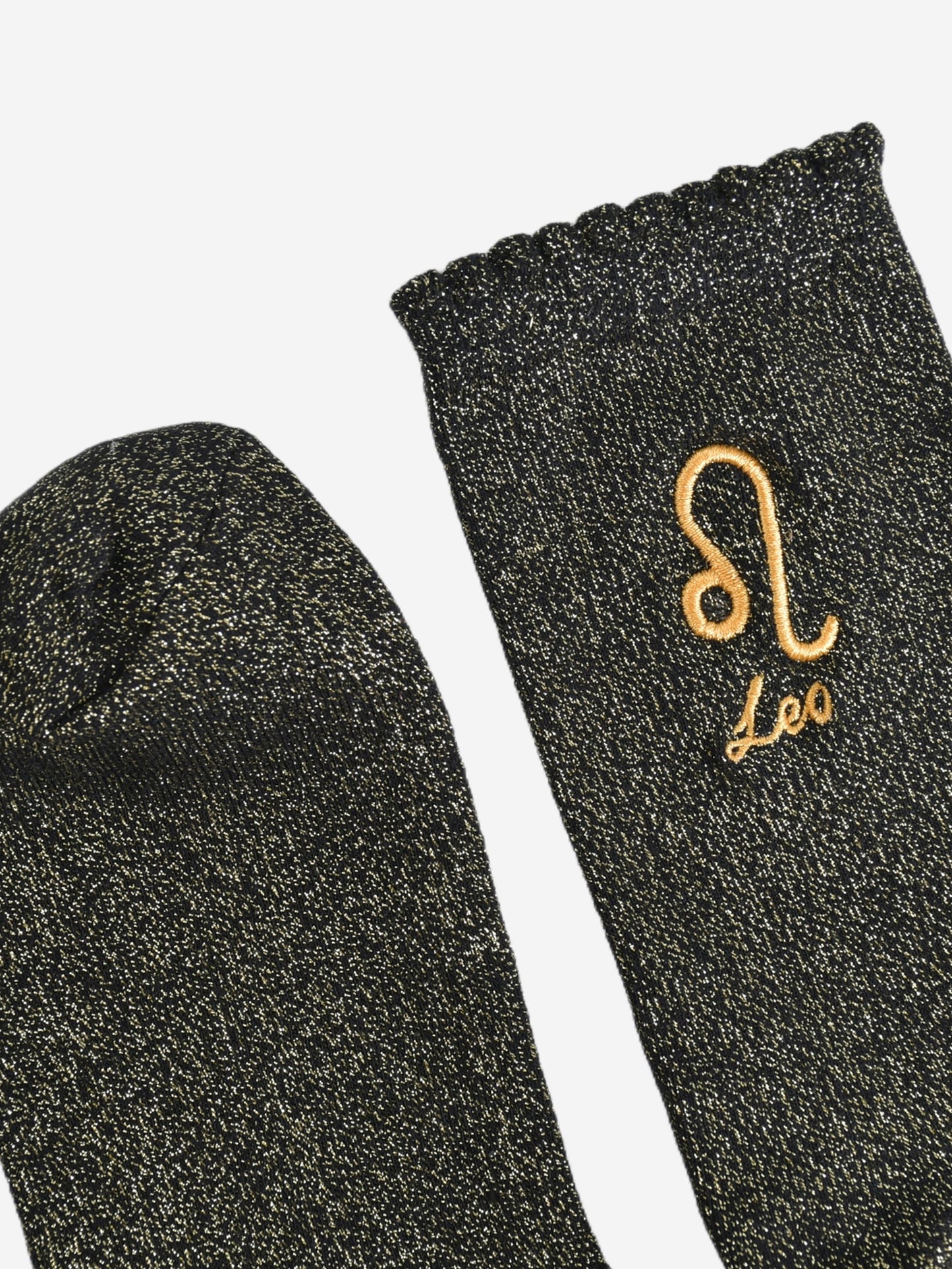 showing the toe and cuff of the socks, they are the same black and gold sparkly colour as the body of the socks, the cuff is scalloped shaped like a slight frill