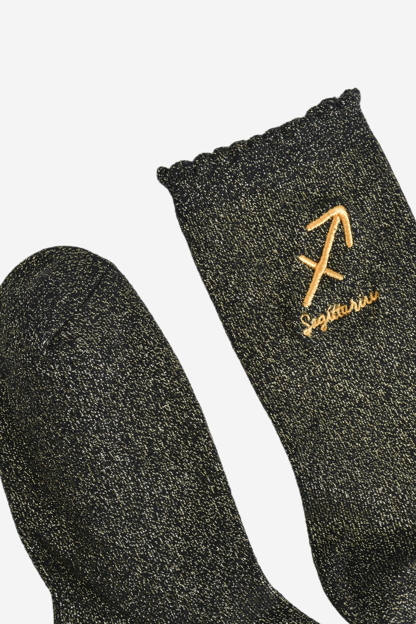 showing the toe and cuff of the socks, they are the same black and gold sparkly colour as the body of the socks, the cuff is scalloped shaped like a slight frill