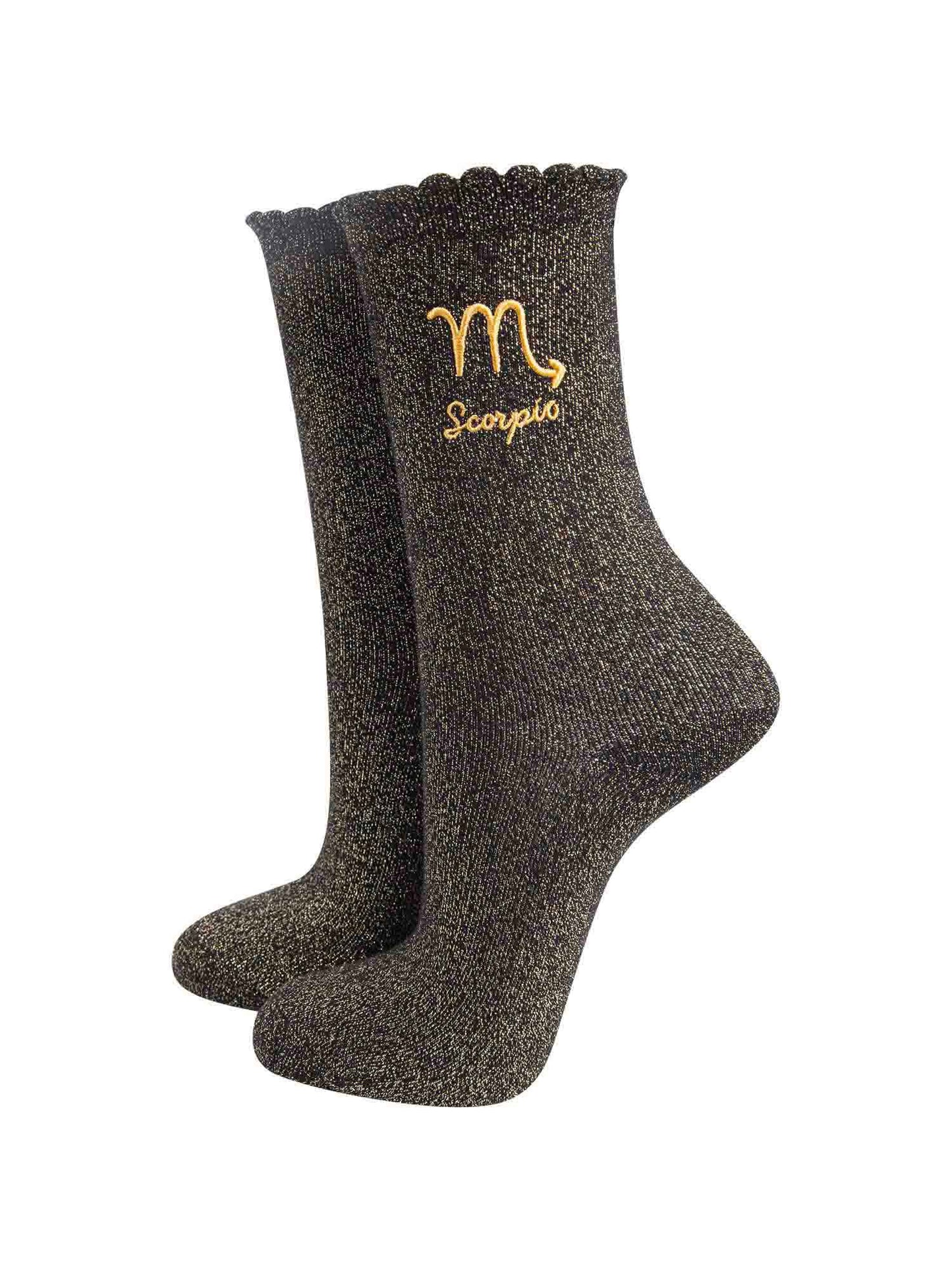 black and gold sparkly ankle socks with a scalloped cuff and an gold embroidered scorpio zodiac symbol and name
