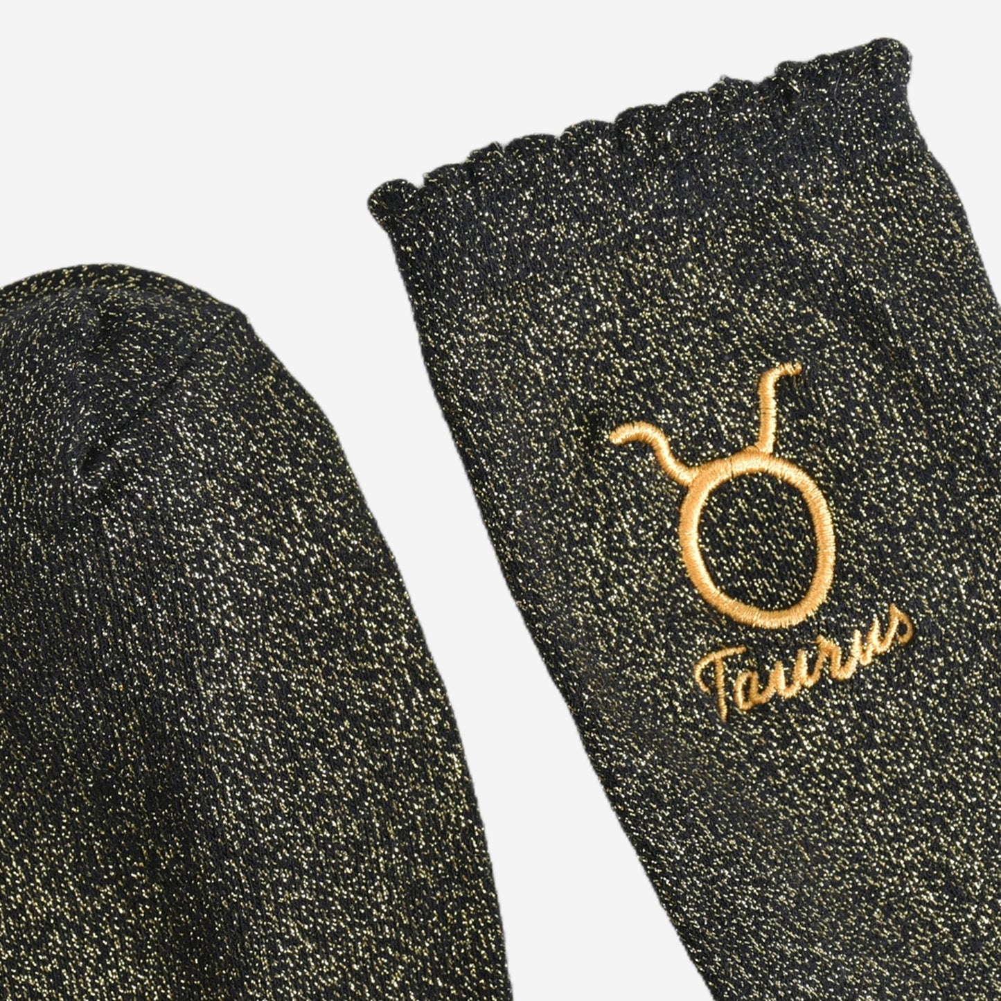 showing the toe and cuff of the socks, they are the same black and gold sparkly colour as the body of the socks, the cuff is scalloped shaped like a slight frill