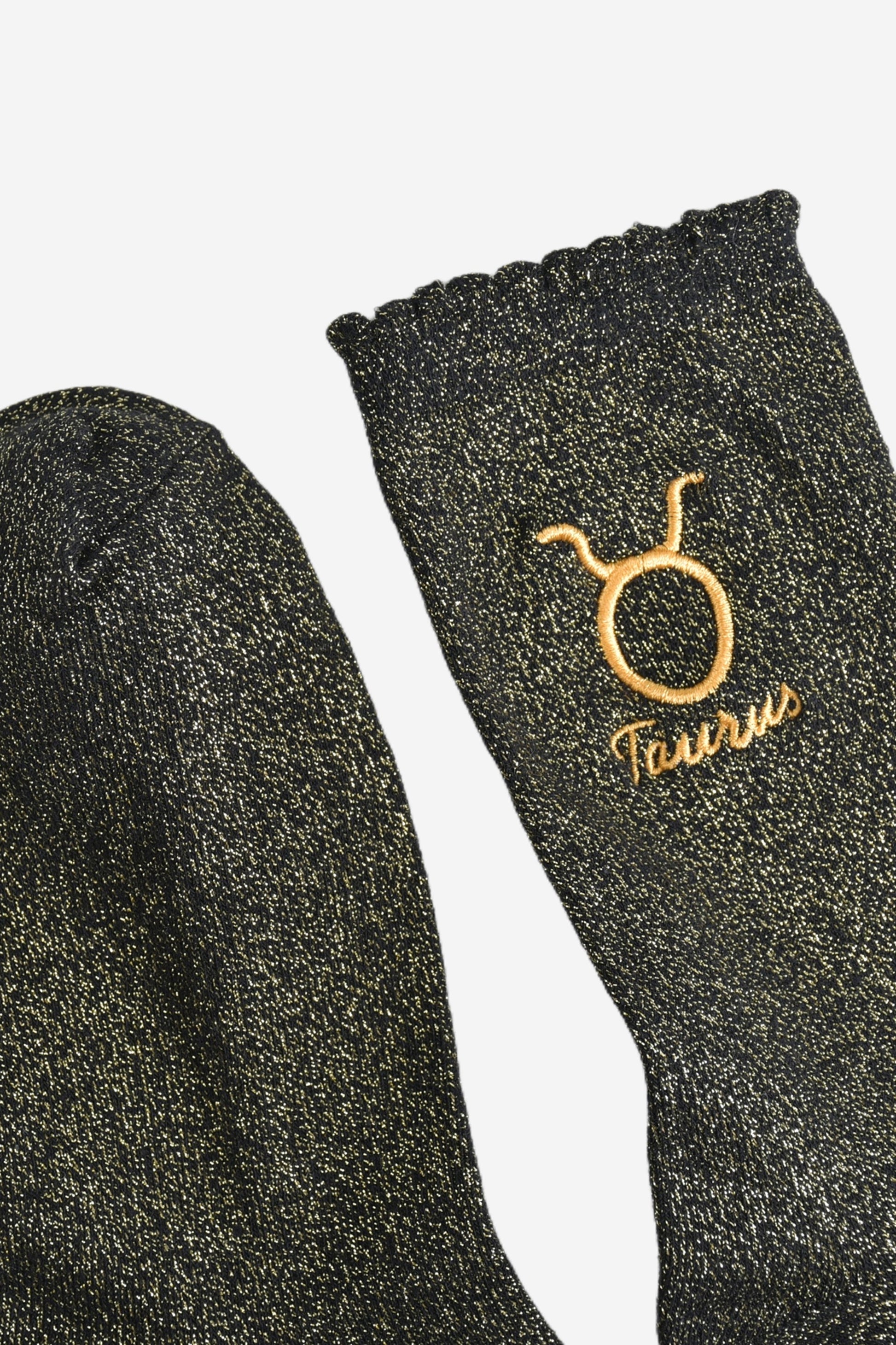 showing the toe and cuff of the socks, they are the same black and gold sparkly colour as the body of the socks, the cuff is scalloped shaped like a slight frill