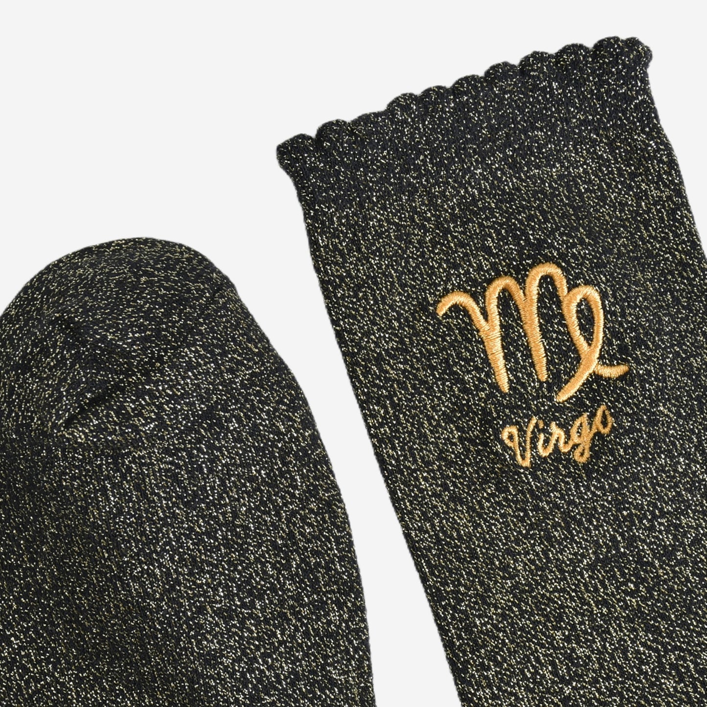 showing the toe and cuff of the socks, they are the same black and gold sparkly colour as the body of the socks, the cuff is scalloped shaped like a slight frill