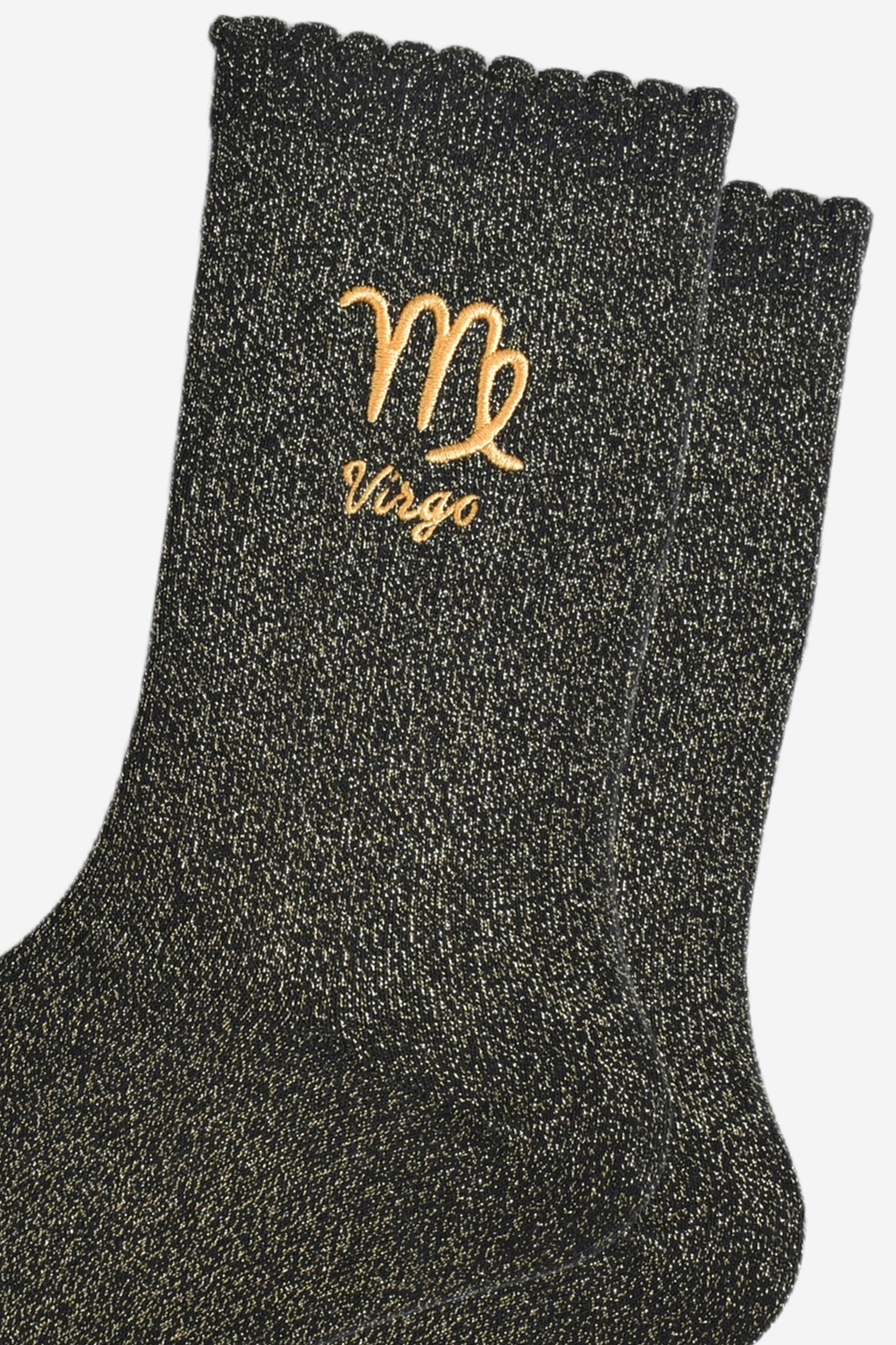 close up of the gold embroidered zodiac detail on the ankle of the socks, showing clearly the symbol of and word virgo