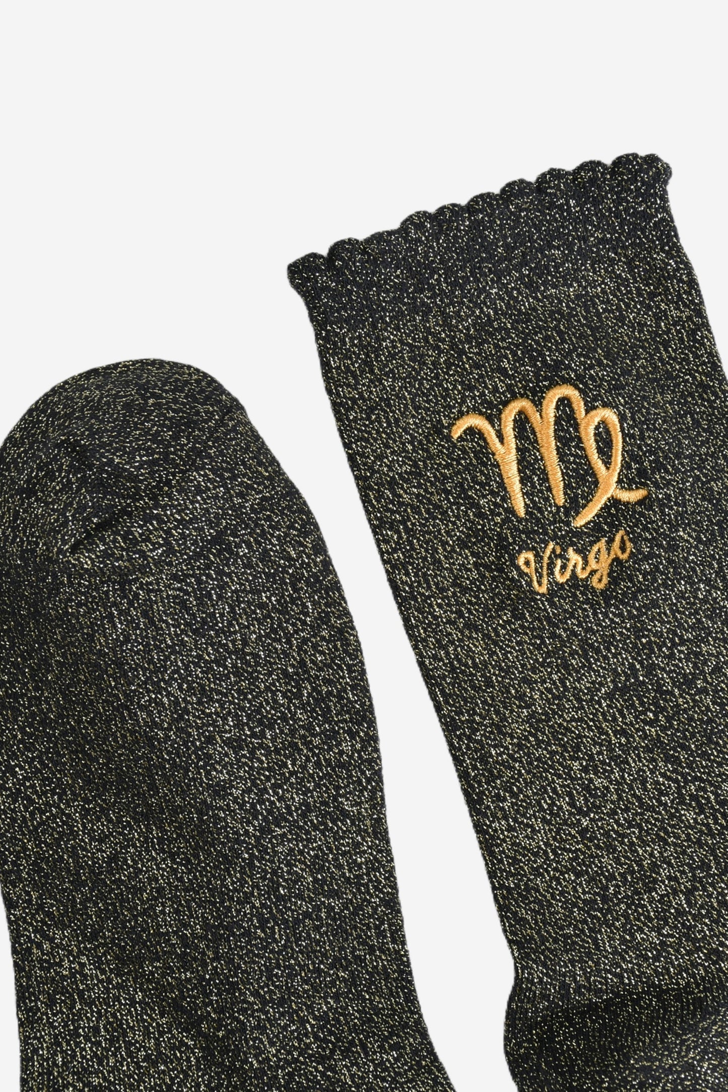 showing the toe and cuff of the socks, they are the same black and gold sparkly colour as the body of the socks, the cuff is scalloped shaped like a slight frill