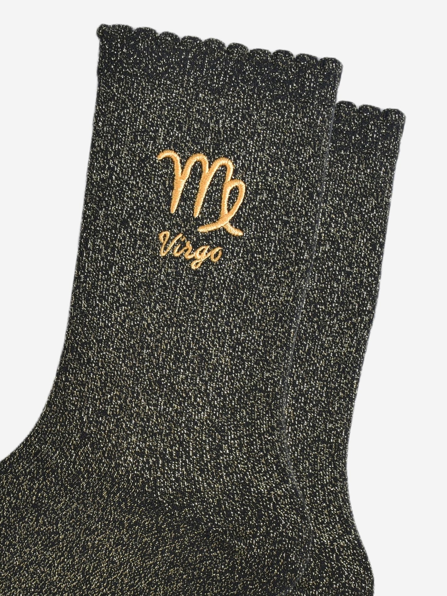 close up of the gold embroidered zodiac detail on the ankle of the socks, showing clearly the symbol of and word virgo