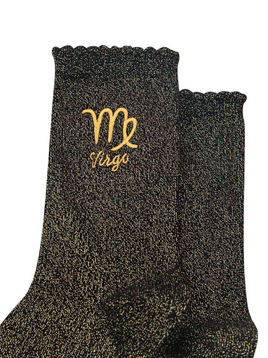 close up of the gold embroidered zodiac detail on the ankle of the socks, showing clearly the symbol of and word virgo