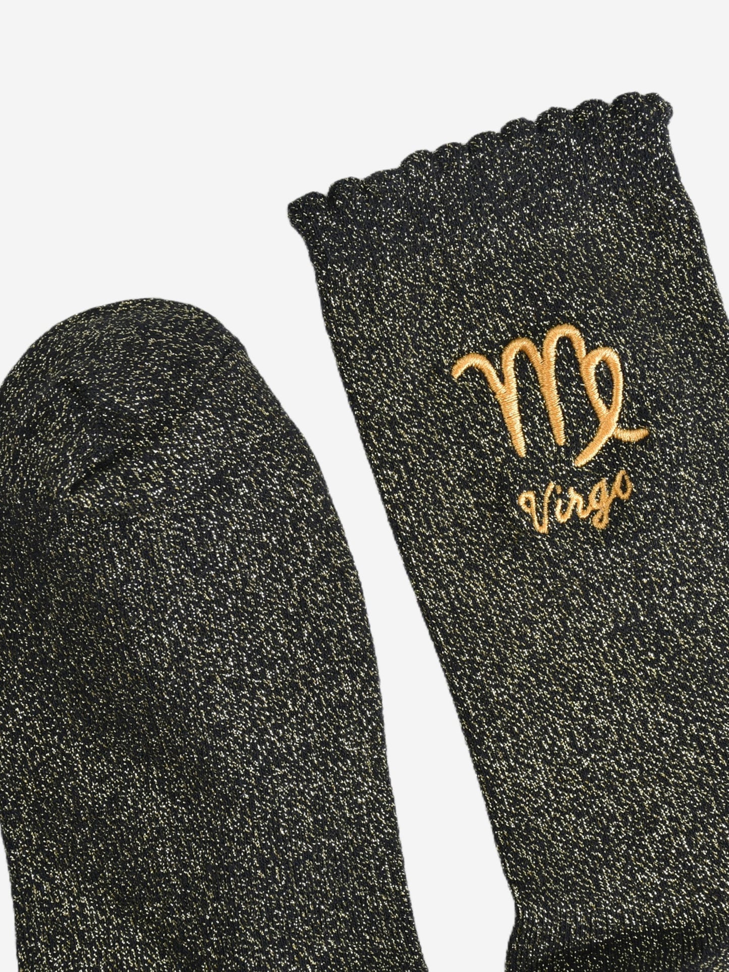 showing the toe and cuff of the socks, they are the same black and gold sparkly colour as the body of the socks, the cuff is scalloped shaped like a slight frill