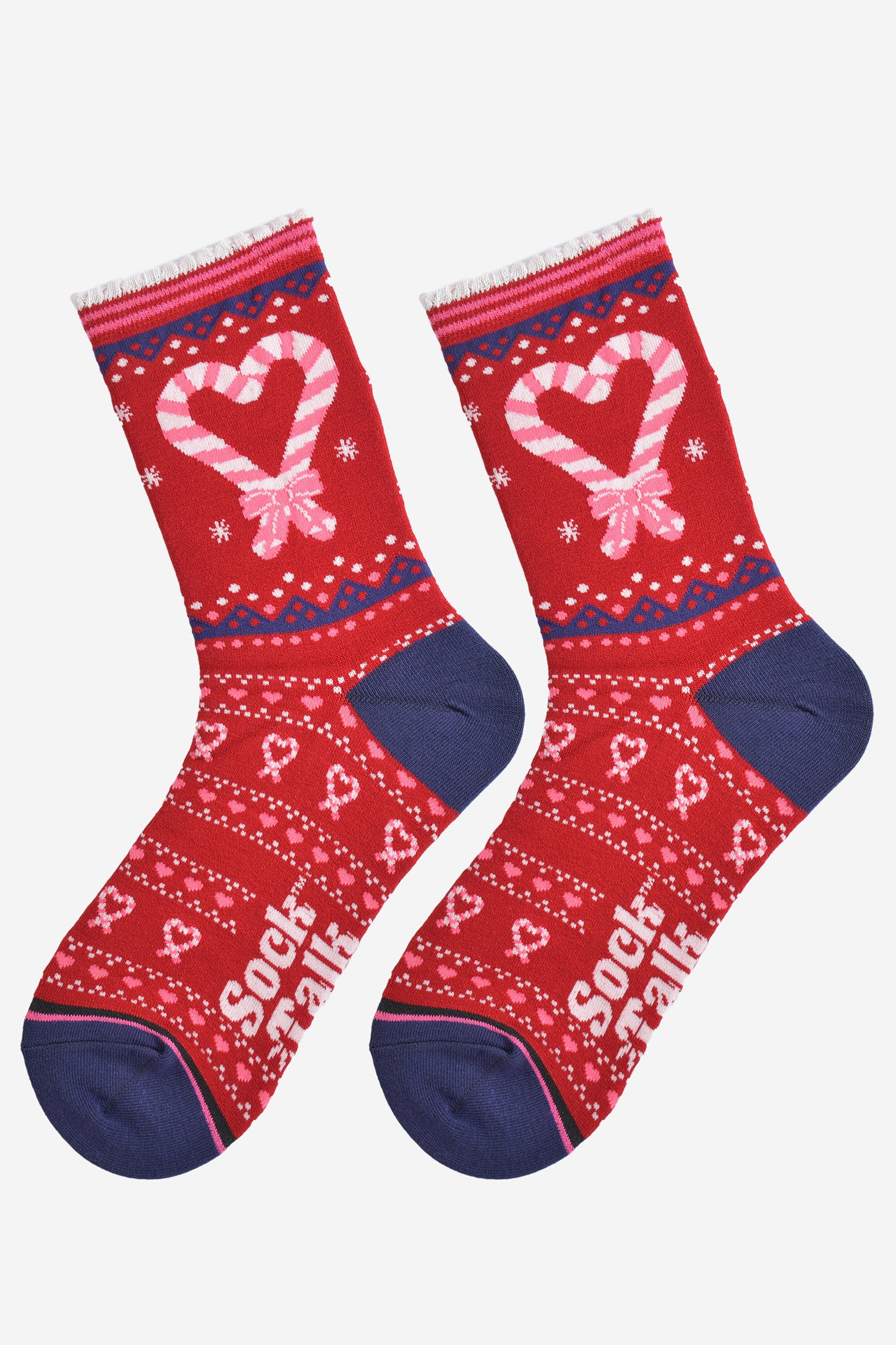 showing the candy cane heart socks laying flat, there is a large candy cane heart on the ankle of the socks along with a fair isle style pattern featuring candy canes on the remainder of the socks