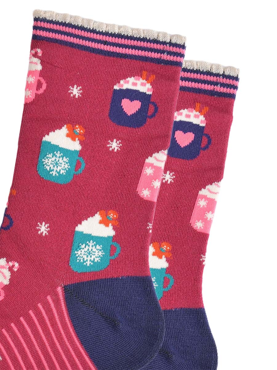 close up of the hot drinks design on the socks, there are teal coloured mugs with a white snowflake pattern topped with whipped creme and a gingerbread man cookie, there are pink mugs with pink candy canes and navy mugs with pink love hearts with pink sugar hearts and cinnamon sticks.