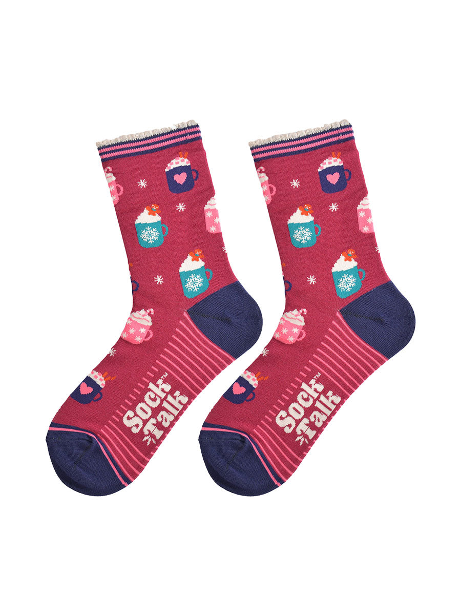 showing the hot drinks socks laying flat, the sole has a pink striped pattern, the toe and heel are navy blue and contrast the berry red colour of the socks, the festive hot drinks pattern is all over the design.