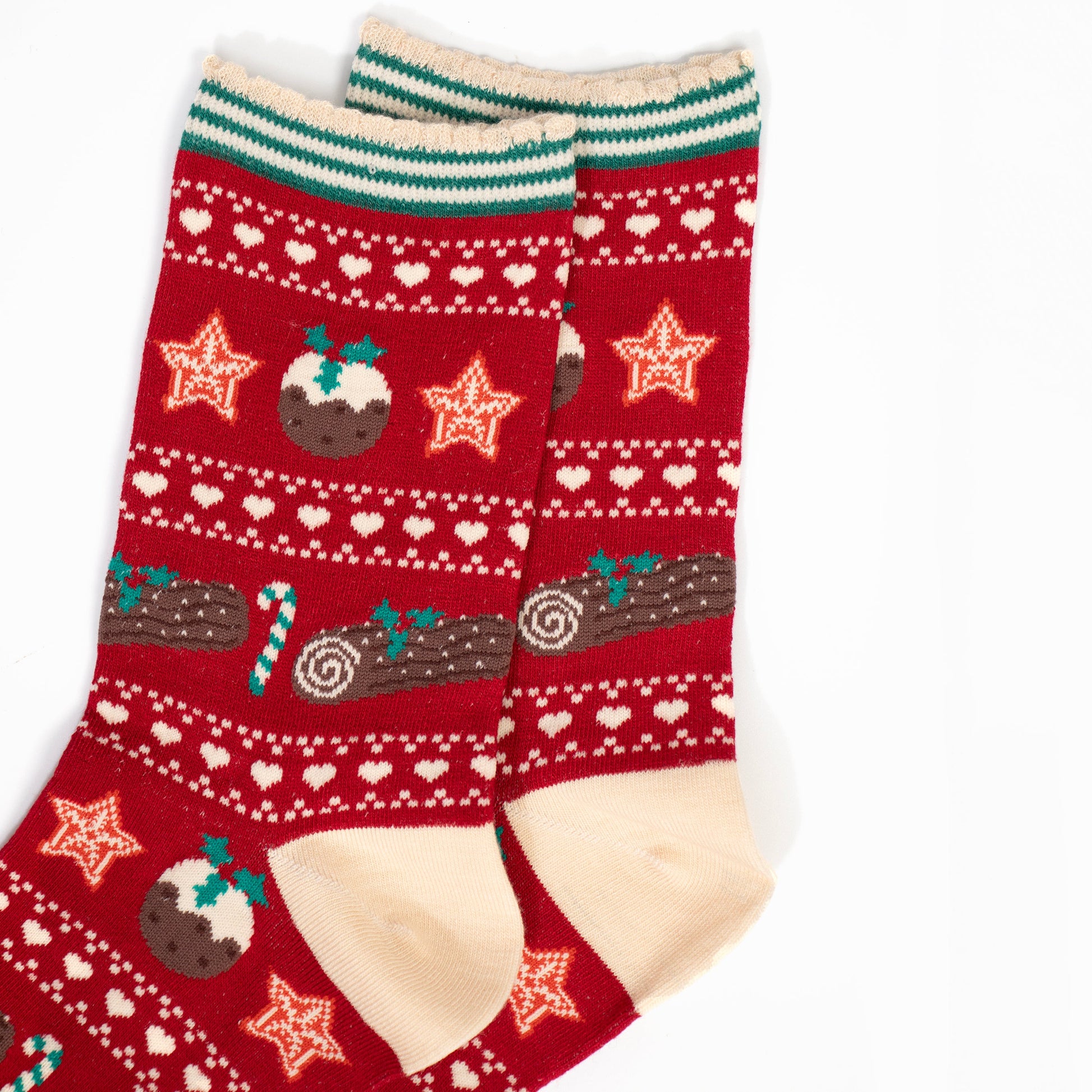 close up of the fair isle pattern, there are christmas puddings, christmas stars, green and white candy canes and chocolate yule logs with holly. 
