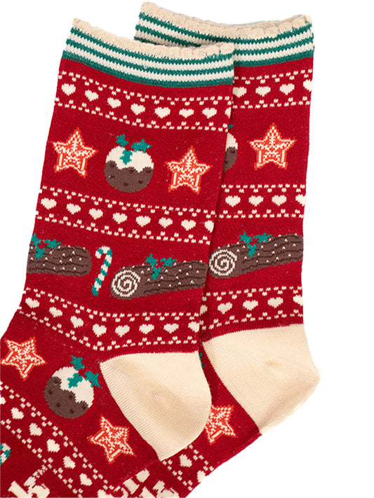 close up of the fair isle pattern, there are christmas puddings, christmas stars, green and white candy canes and chocolate yule logs with holly. 