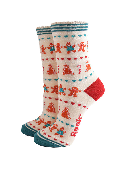 cream bamboo socks with a fair isle inspired gingerbread cookie pattern all over, the heel is red, the toe is green and the socks have scalloped cuff edges.