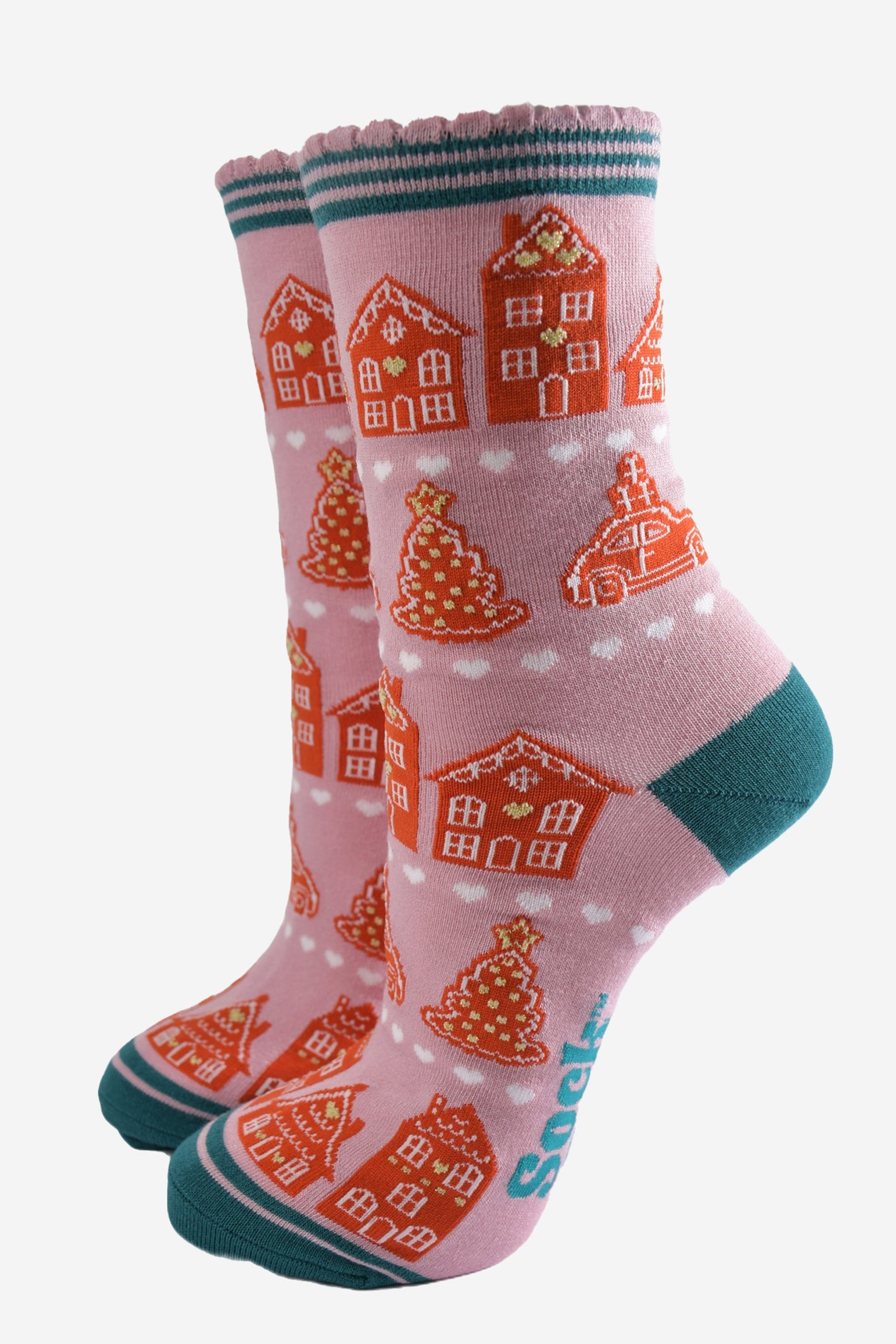 pink socks with an all over pattern of gingerbread houses and cookies