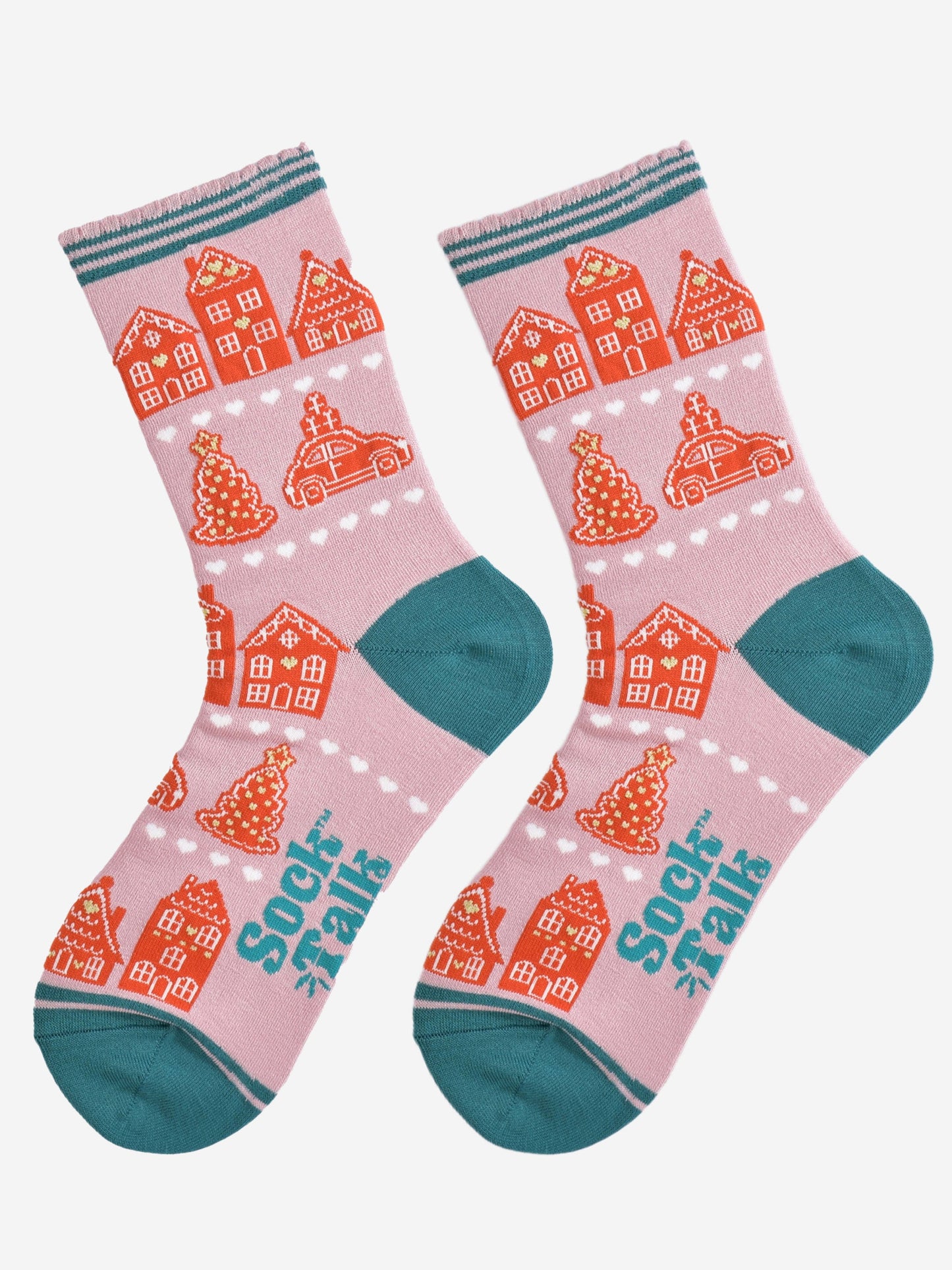 showing the gingerbread house socks laying flat, the pattern is in rows separated by white love heats, the toe and heel of the socks are teal blue in contrast to the light pink background.