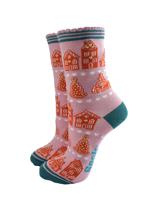 pink socks with an all over pattern of gingerbread houses and cookies