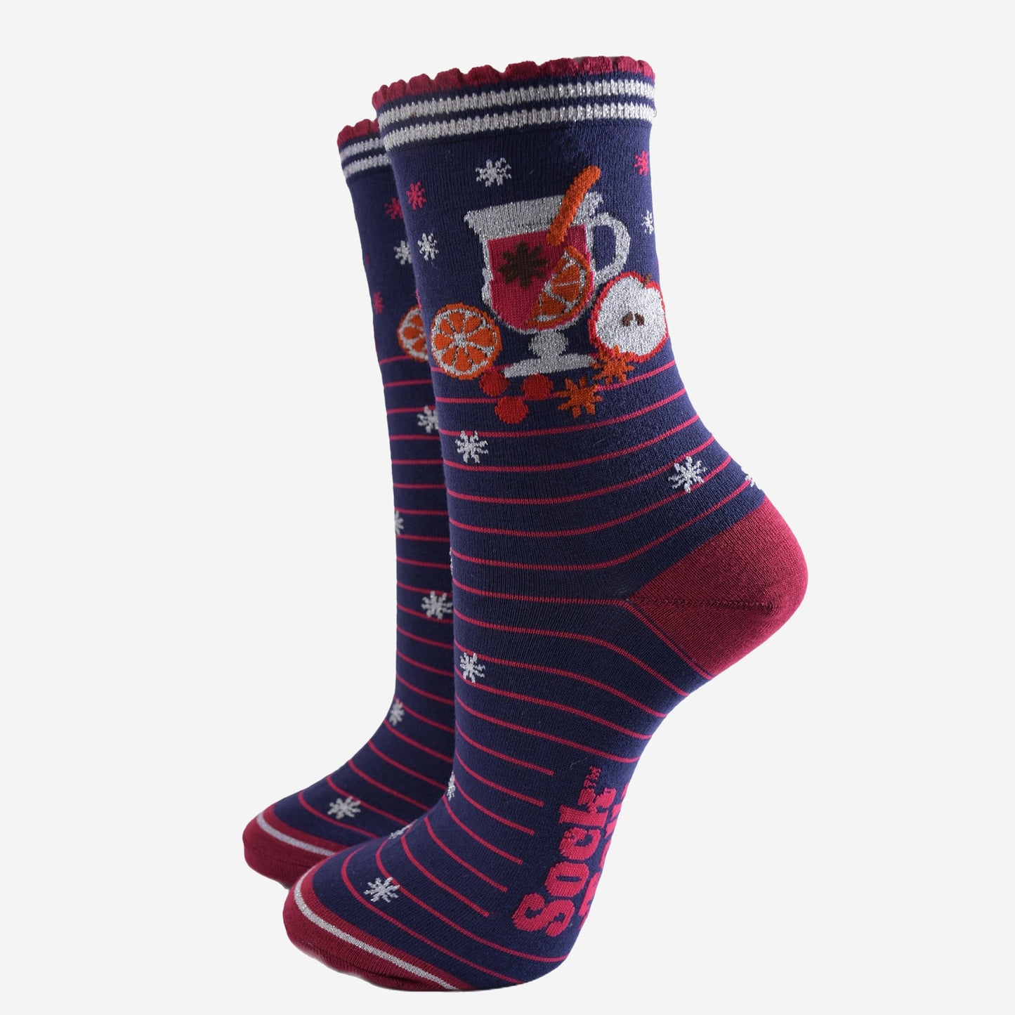 navy blue socks with pink stripes and a mulled wine carafe with fruit and spices on the ankle.