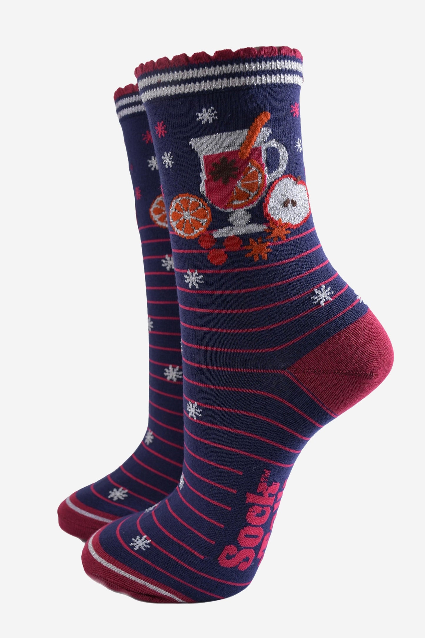 navy blue socks with pink stripes and a mulled wine carafe with fruit and spices on the ankle.