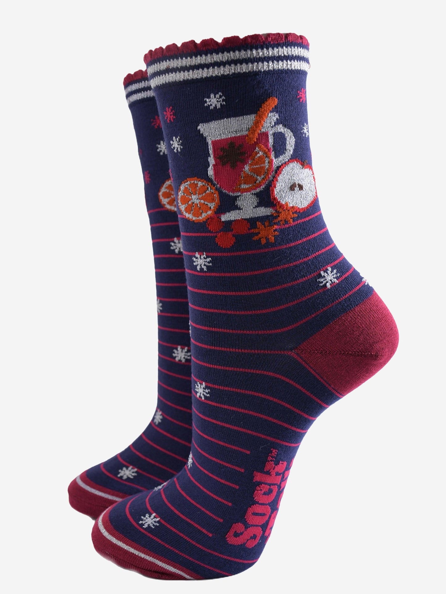 navy blue socks with pink stripes and a mulled wine carafe with fruit and spices on the ankle.