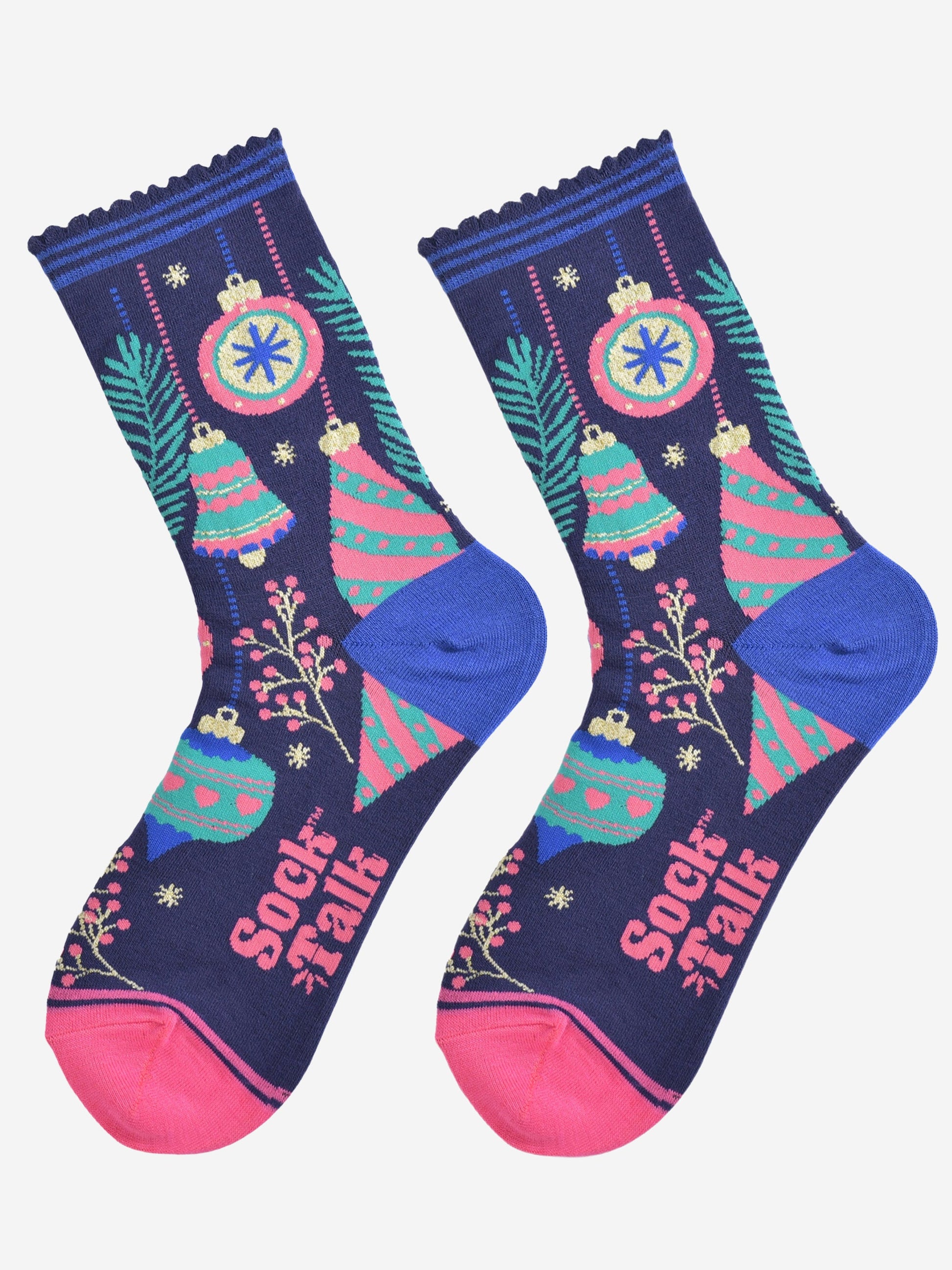 christmas tree bauble socks laying flat, showing an all over colourful design in blue, green and pink. there are festive baubles, xmas tree bells, small tree branches and berries.