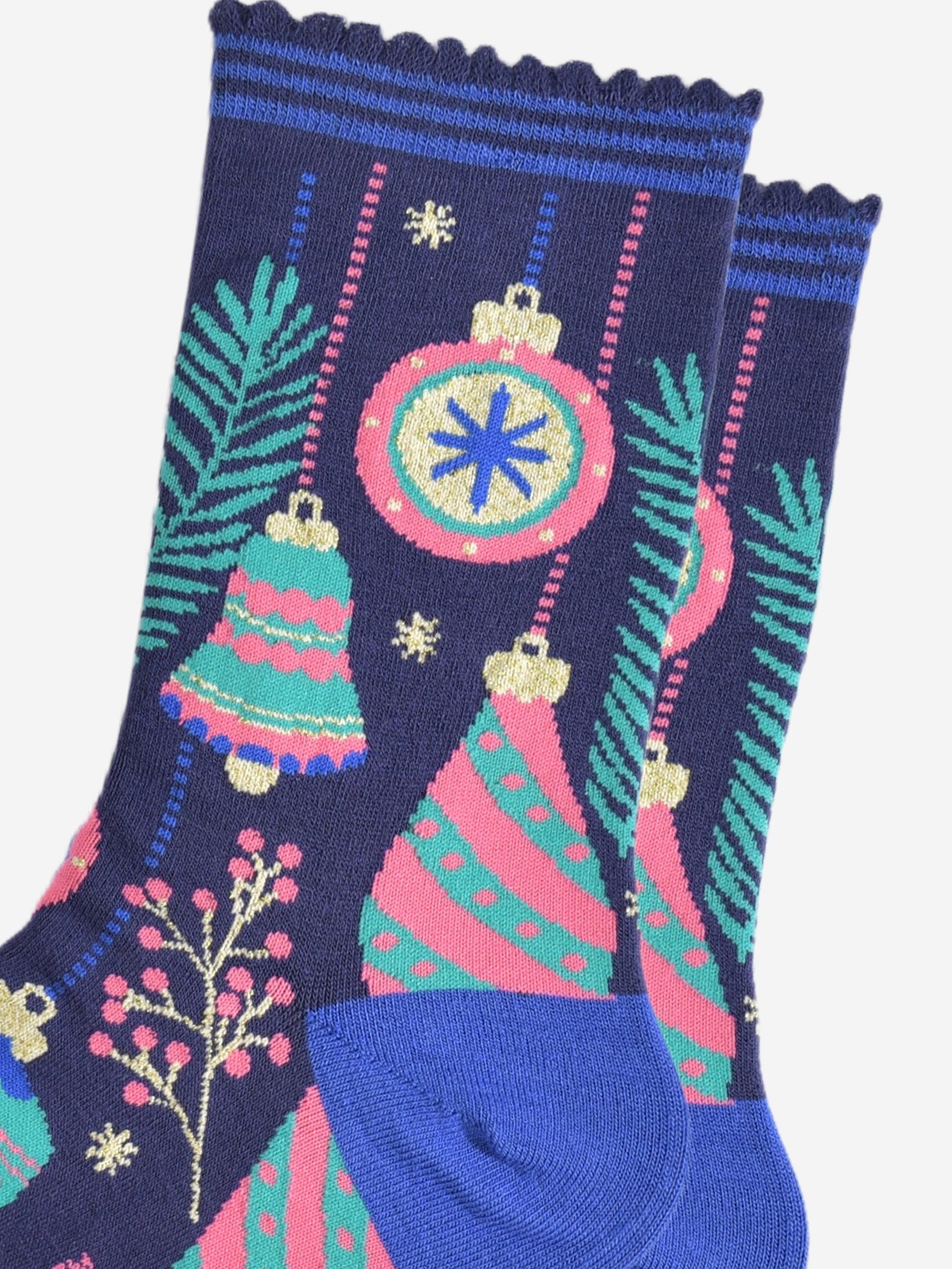 close up of the ornate xmas bauble pattern, there are round baubles with and bells, each are multi-coloured in pink, mint green. royal blue and gold.