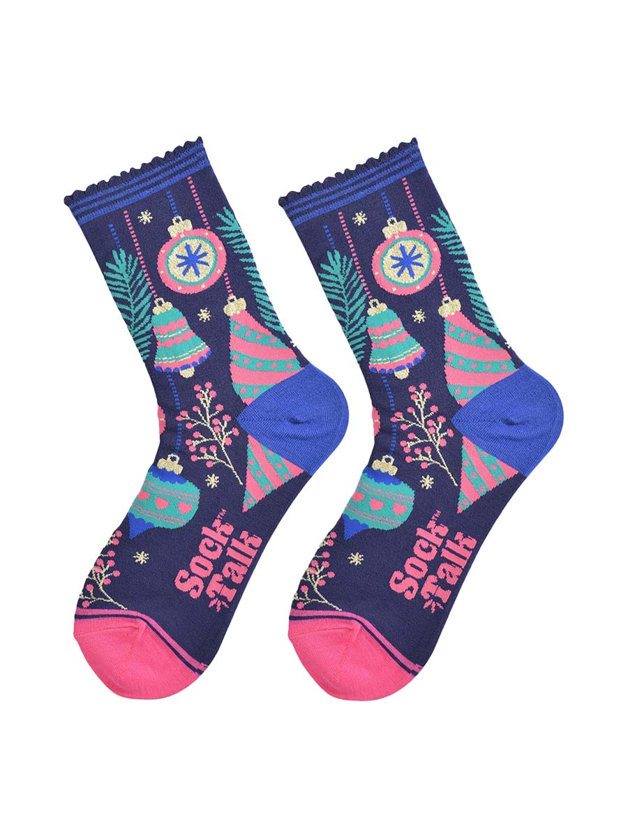 christmas tree bauble socks laying flat, showing an all over colourful design in blue, green and pink. there are festive baubles, xmas tree bells, small tree branches and berries.