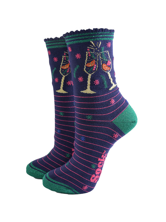 navy blue socks with pink stripes and green heel, toe and striped cuff, on the ankle is a multicoloured design showing two clinking cocktail flutes with a fruity sparking drink inside
