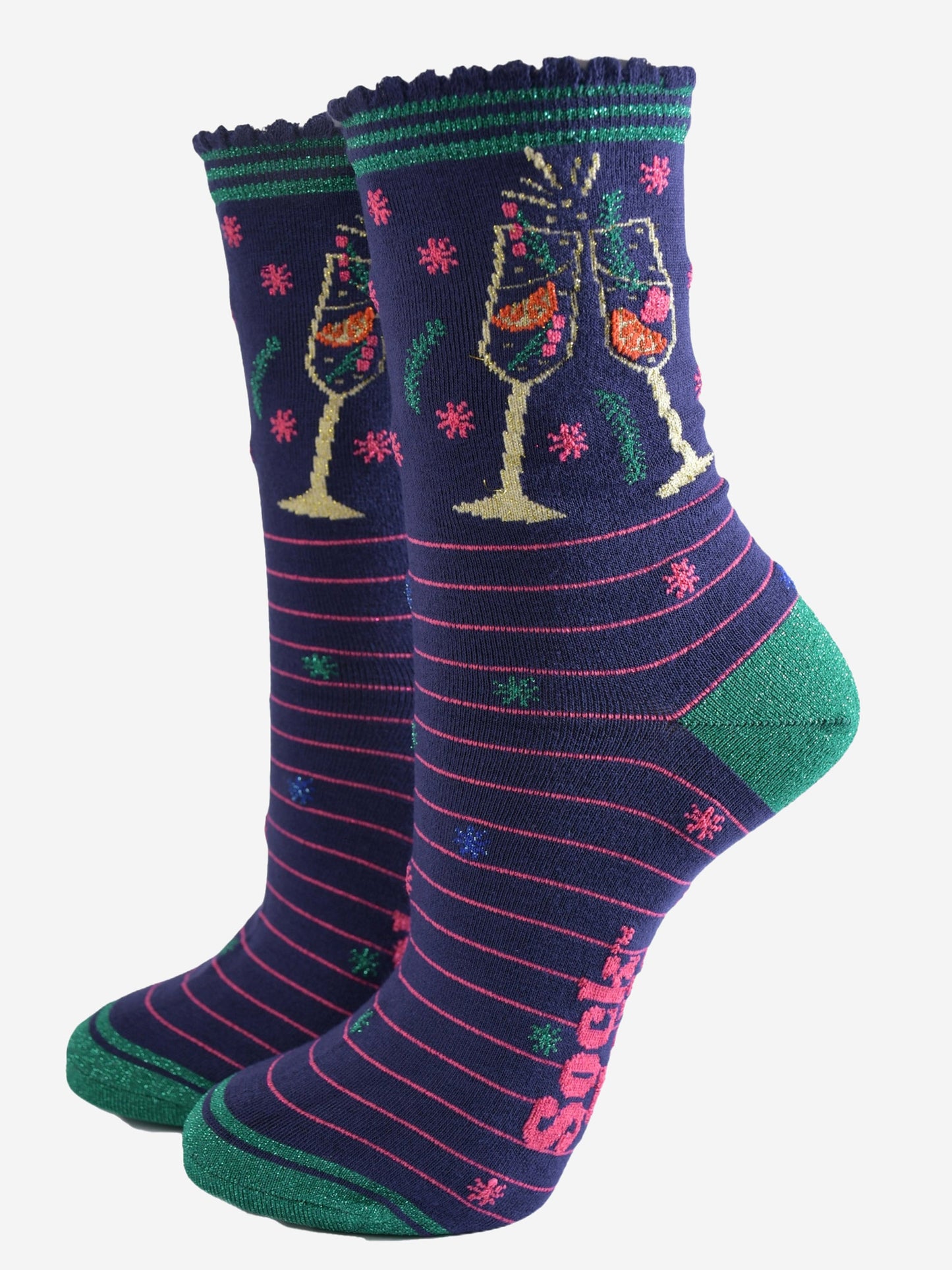 navy blue socks with pink stripes and green heel, toe and striped cuff, on the ankle is a multicoloured design showing two clinking cocktail flutes with a fruity sparking drink inside