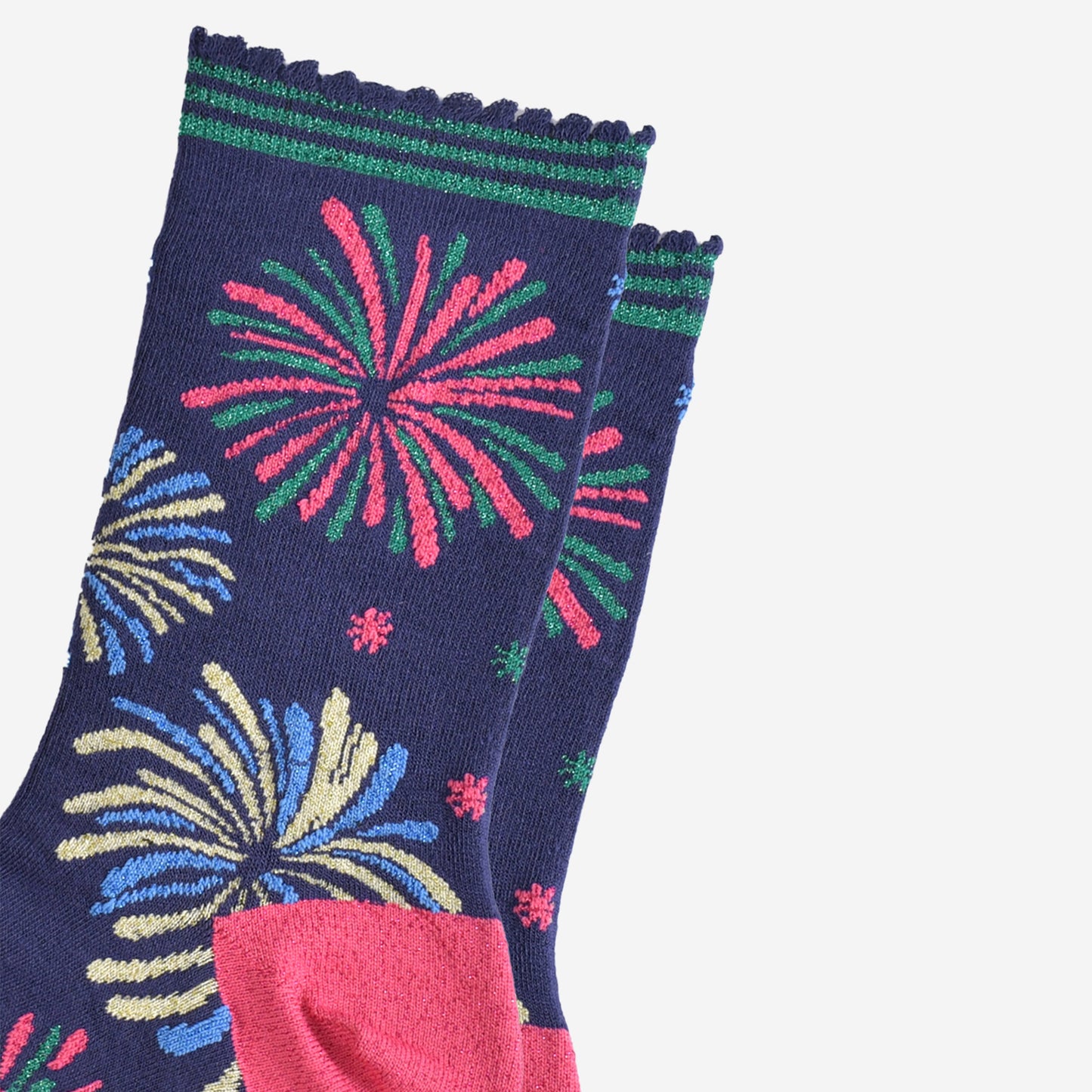 close up of the sparkly fireworks on the socks, they are all in two colours and look like they are exploding in the sky. there are pink and green fireworks, blue and gold fireworks and blue and green fireworks