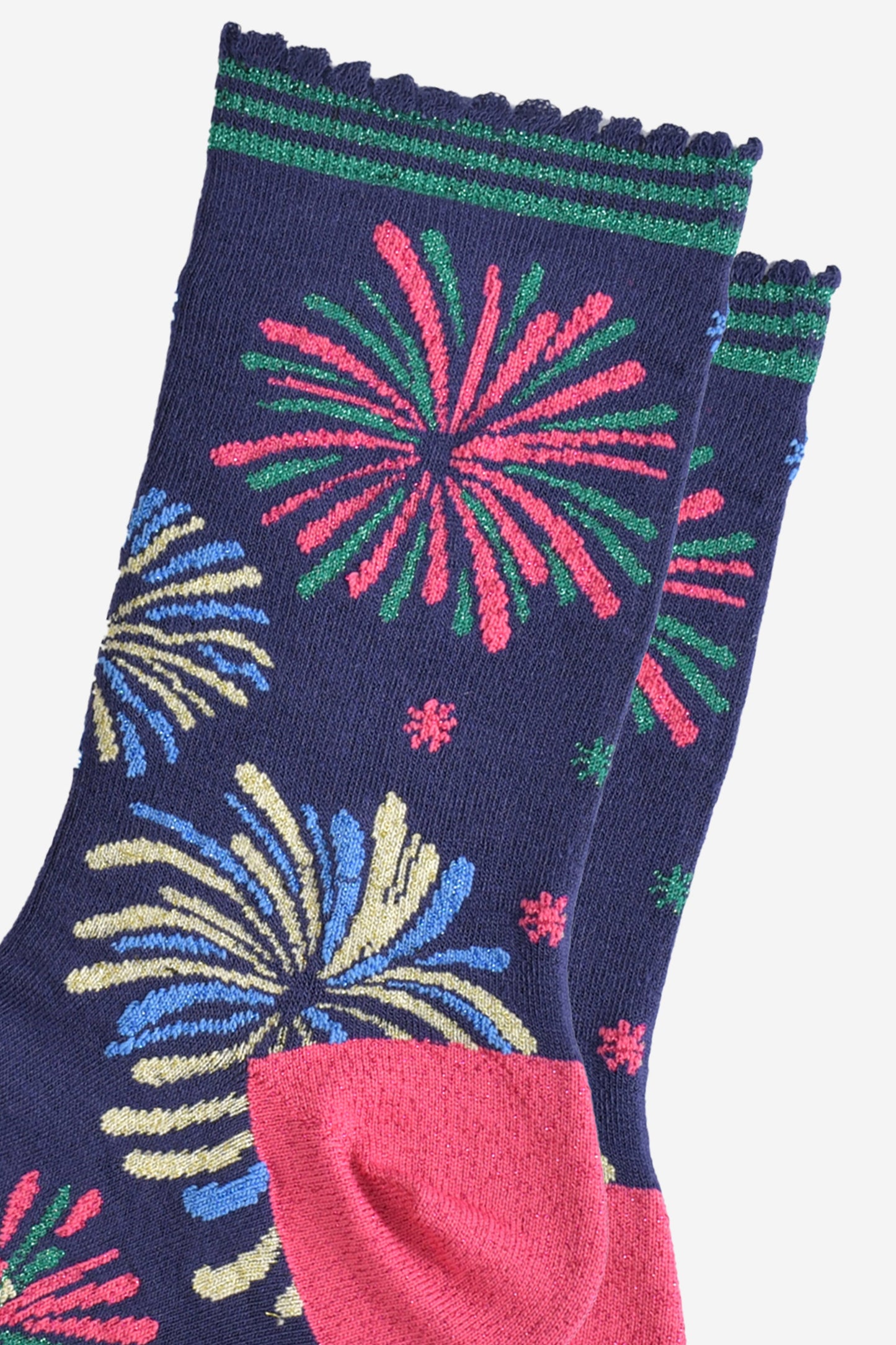 close up of the sparkly fireworks on the socks, they are all in two colours and look like they are exploding in the sky. there are pink and green fireworks, blue and gold fireworks and blue and green fireworks