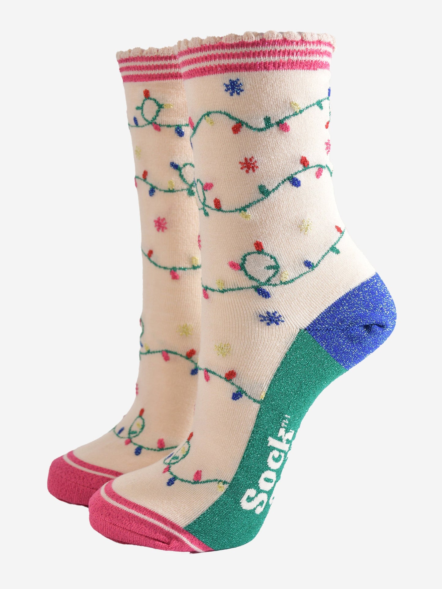 cream bamboo socks with an all over pattern of multicoloured party lights. the soles are green. the heel is blue and the socks have sparkly glitter accents