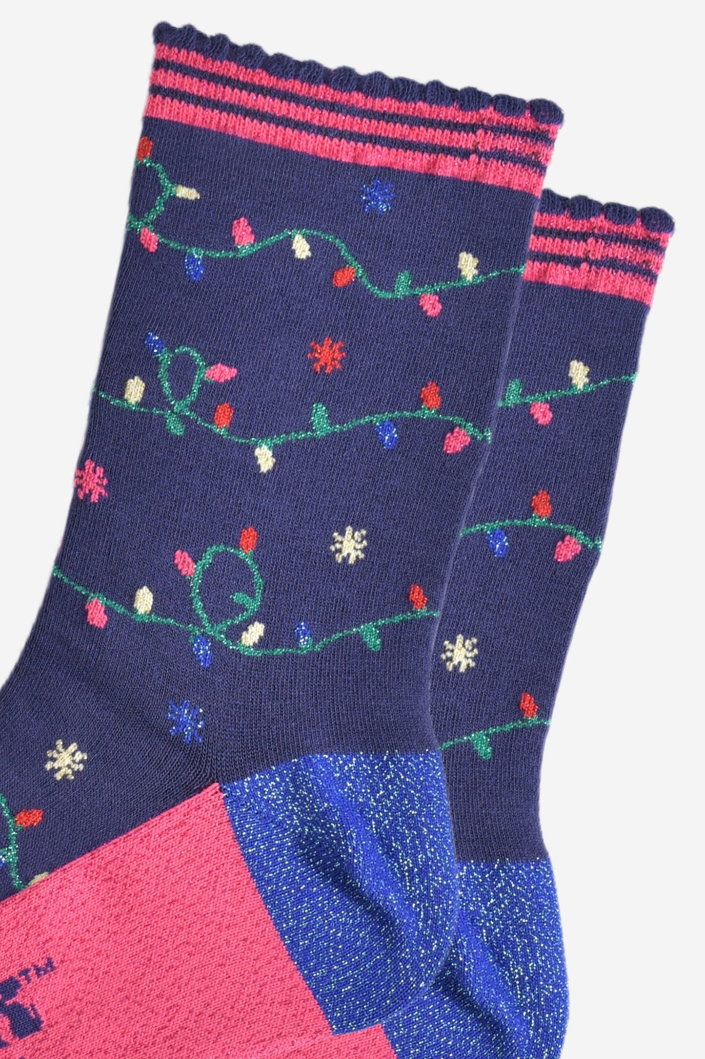 close up of the multicoloured party light design on the socks, the lights are attached to a green string and wrap around the socks, the socks have sparkly glitter accents