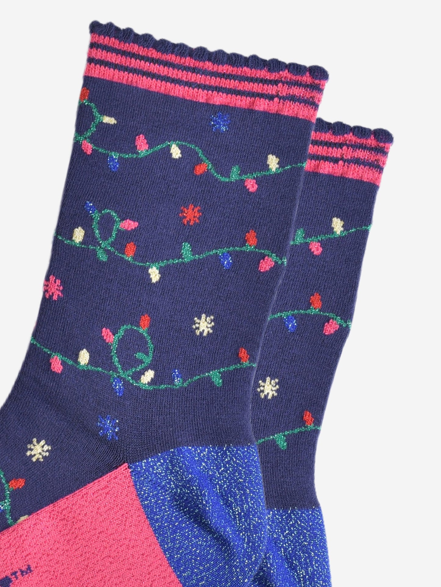 close up of the multicoloured party light design on the socks, the lights are attached to a green string and wrap around the socks, the socks have sparkly glitter accents