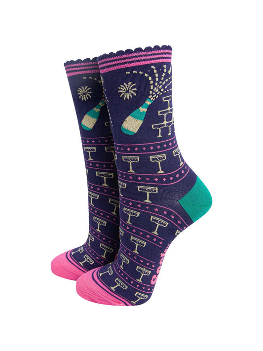 navy blue socks with a pattern of popping champagne bottles and vintage coupe glasses, the socks have a pink striped scalloped cuff 