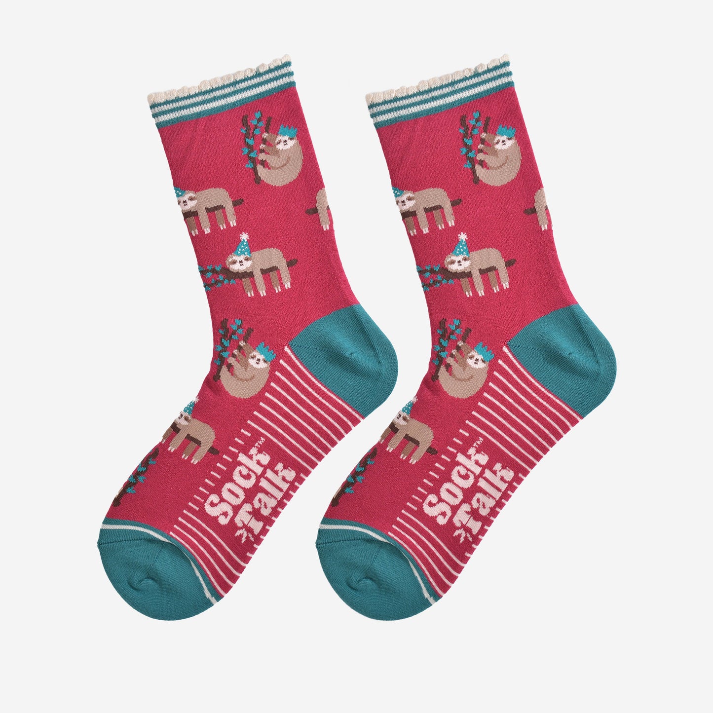 showing the festive sloth socks laying flat displaying the full pattern, there are sloths laying and climbing on tree branches while wearing green party hats, the sole of the socks have a white striped pattern