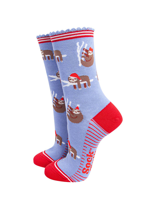 light blue socks with a red heel, toe and striped cuff with a pattern of sleepy sloths wearing santa hats