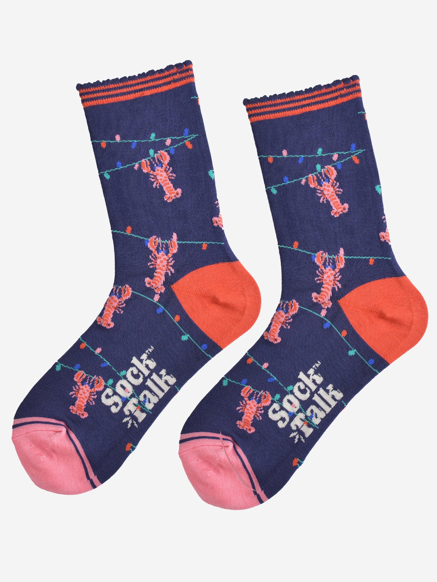 showing the lobster socks laying flat highlighting the all over pattern of the colourful party lights with pink lobsters hanging from them, the toe is pink and the heel is coral in contrast to the navy blue of the socks